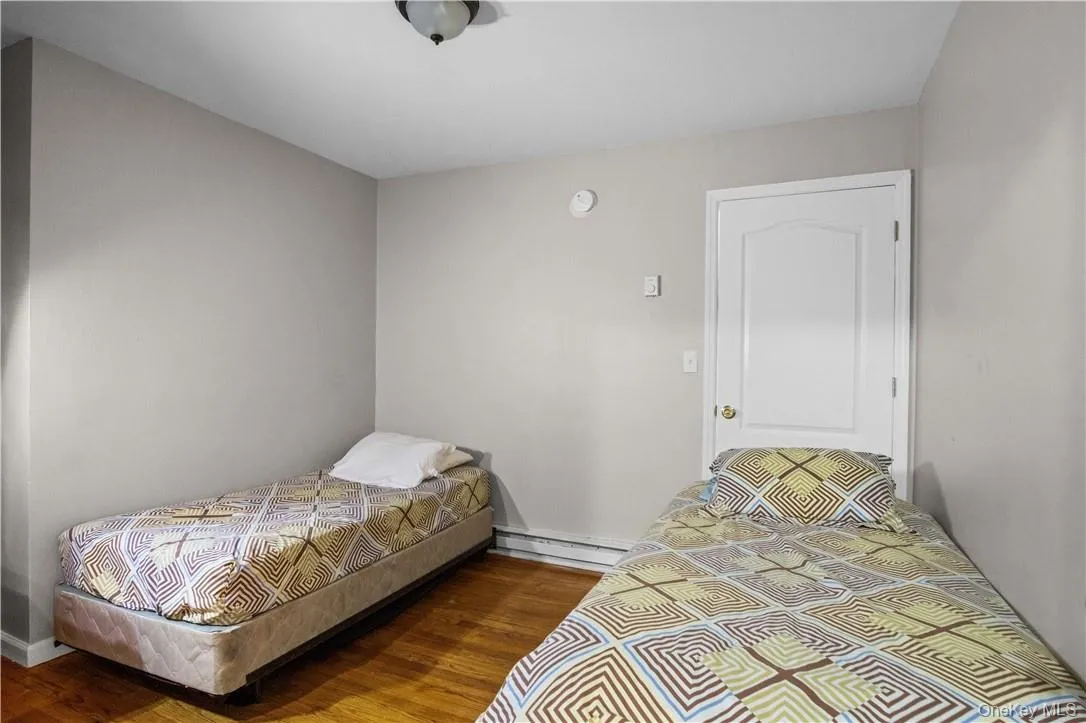 Bedroom with a baseboard radiator and hardwood / wood-style floors Bedroom with a baseboard radiator and hardwood / wood-style floors