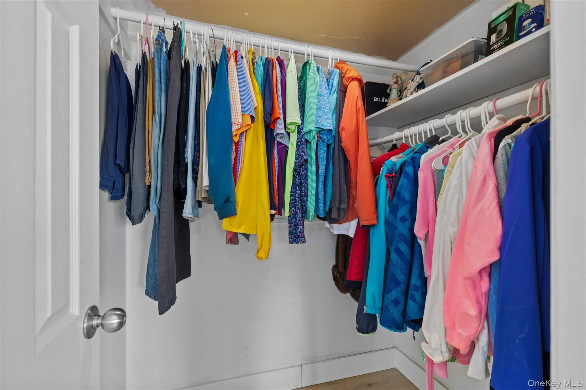 Built-in closet system featuring white shelving and hanging rods Built-in closet system featuring white shelving and hanging rods