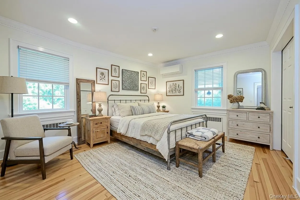 Primary bedroom with wood floors, windows and slider closet ~ ai enhanced Primary bedroom with wood floors, windows and slider closet ~ ai enhanced