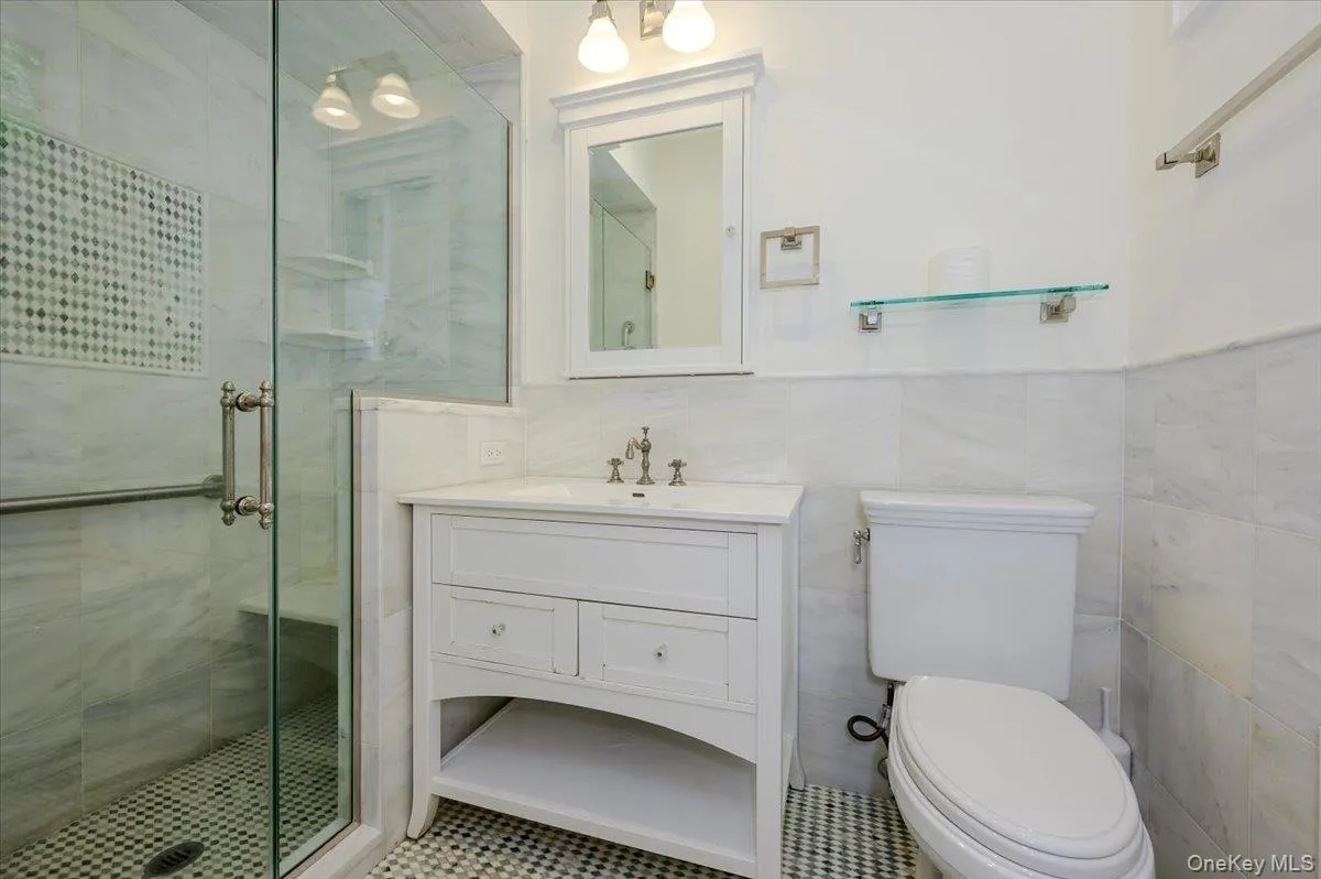 Primary en suite bathroom w/harlequin marble floors, glass shower with marble floors, subway tiled walls and built in bench Primary en suite bathroom w/harlequin marble floors, glass shower with marble floors, subway tiled walls and built in bench