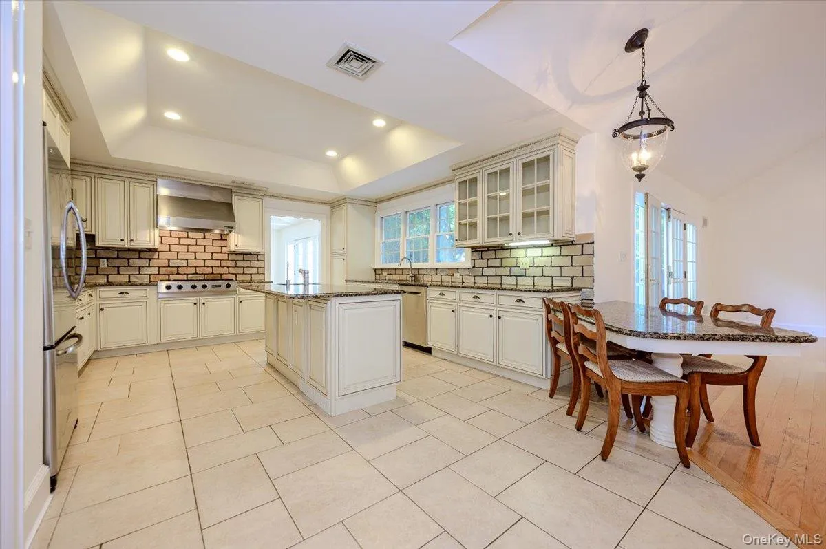 Large center island with granite counter, stainless steel auxiliary sink and dining peninsula Large center island with granite counter, stainless steel auxiliary sink and dining peninsula