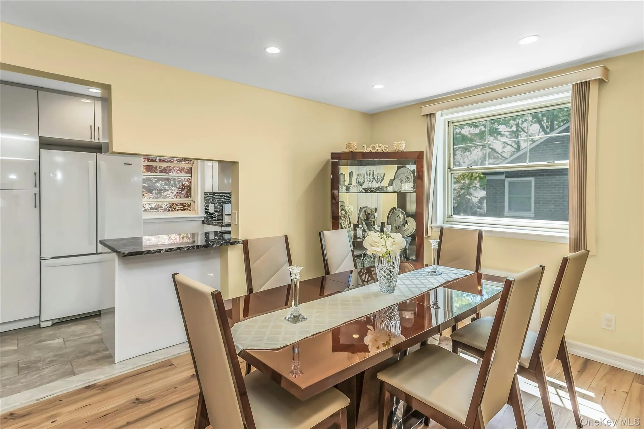 Dining area featuring wood-finish flooring, recessed lighting, and a large window with natural light Dining area featuring wood-finish flooring, recessed lighting, and a large window with natural light