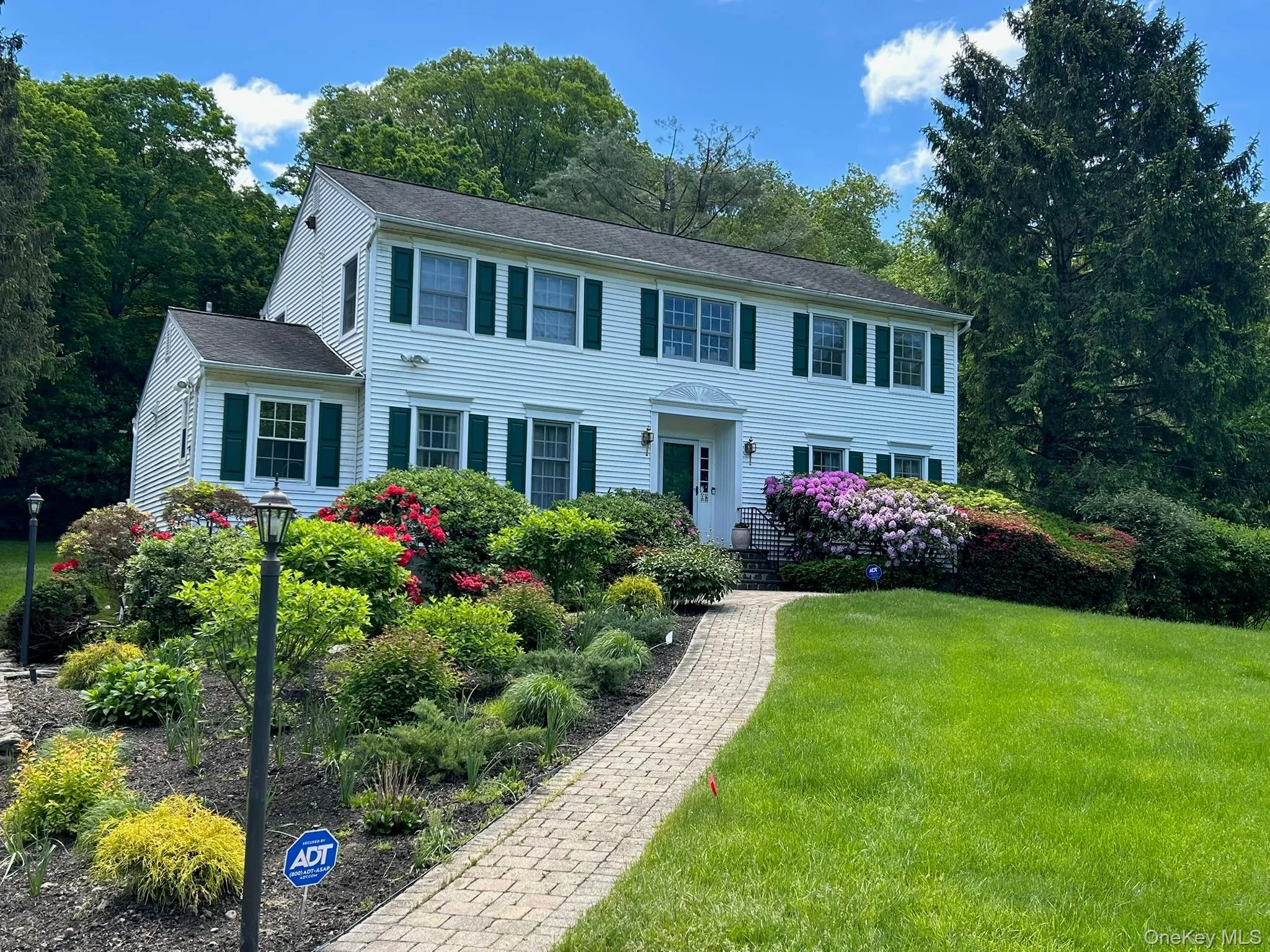 Gardens featuring flowering perennials, specimen shrubs, towering old growth trees, lush expansive front and back lawns Gardens featuring flowering perennials, specimen shrubs, towering old growth trees, lush expansive front and back lawns