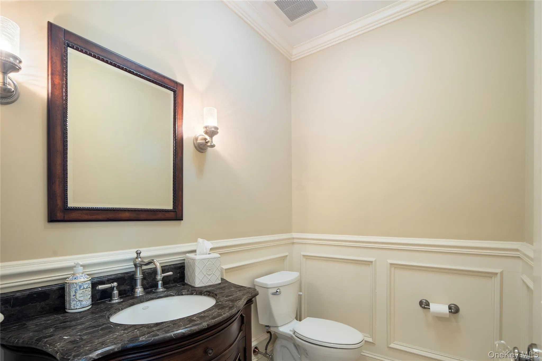 Main floor powder room, marble topped vanity, wainscot wall panels, wall sconces, crown molding Main floor powder room, marble topped vanity, wainscot wall panels, wall sconces, crown molding