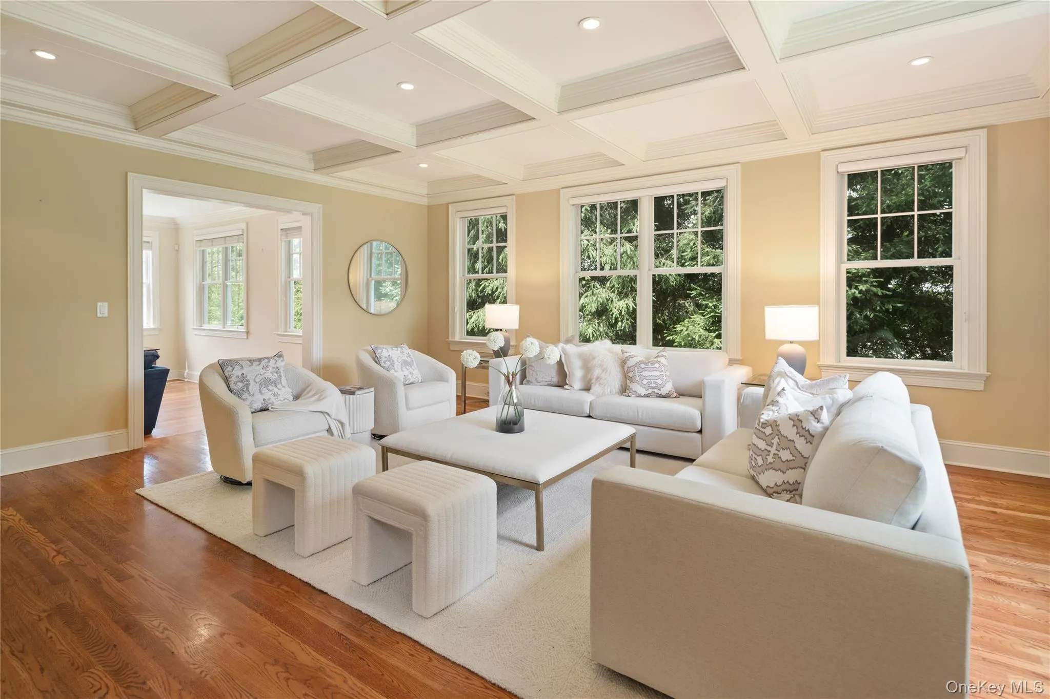 Formal living room with coffered ceiling, recessed lighting, many windows and oak hardwood floors, open to the family room. Formal living room with coffered ceiling, recessed lighting, many windows and oak hardwood floors, open to the family room.