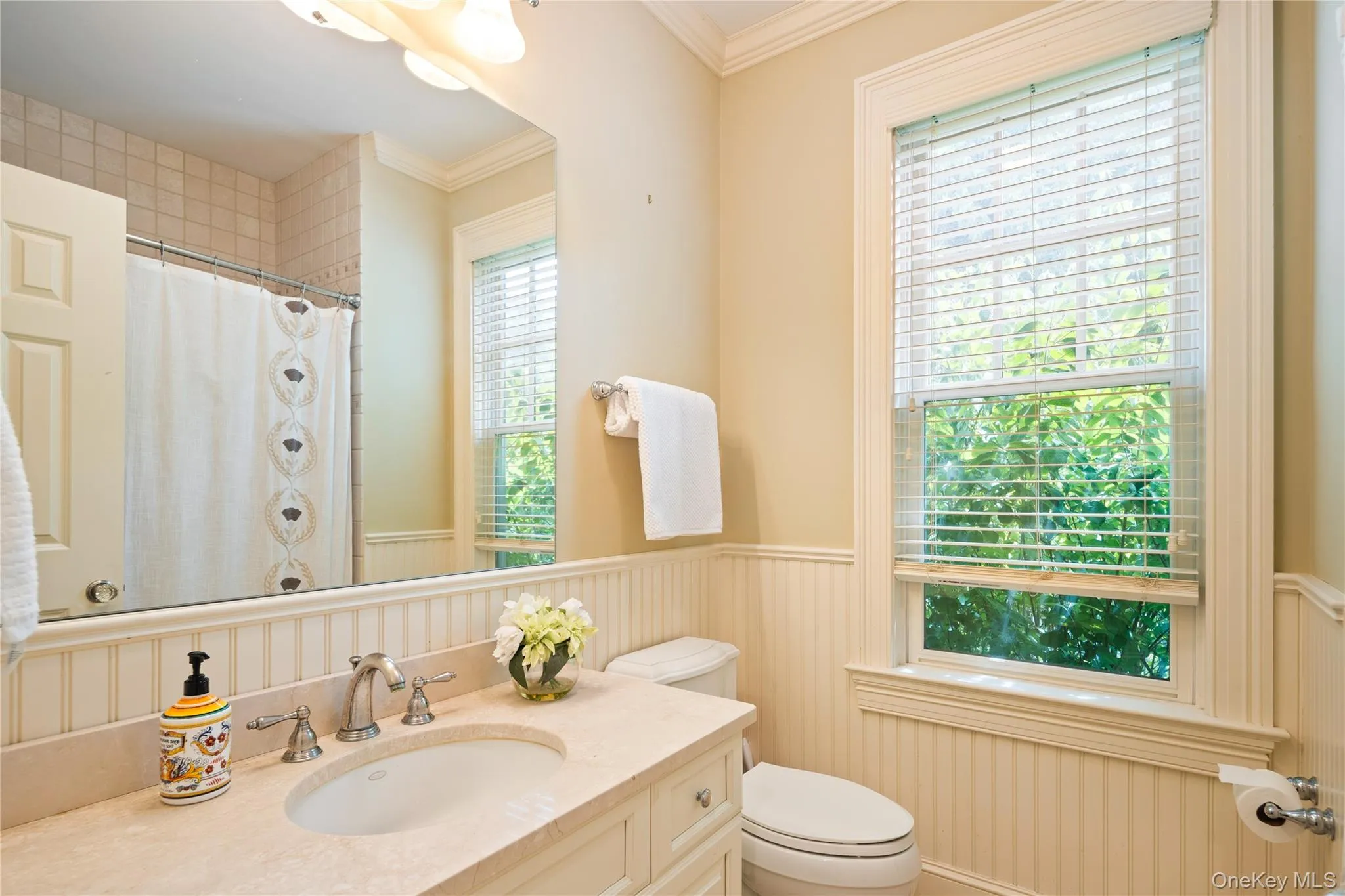 Main floor full bath next to 5th bedroom with beadboard wainscot, storage vanity with undermount sink, crown molding, wall sconce, full tub/shower combo, Kohler fixtures Main floor full bath next to 5th bedroom with beadboard wainscot, storage vanity with undermount sink, crown molding, wall sconce, full tub/shower combo, Kohler fixtures