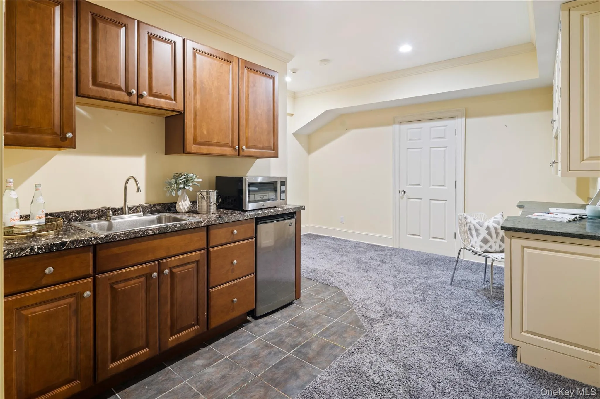 Lower level wet bar with sink, beverage refrigerator and microwave, addtional storage cabinetry with granite counters on opposite wall Lower level wet bar with sink, beverage refrigerator and microwave, addtional storage cabinetry with granite counters on opposite wall