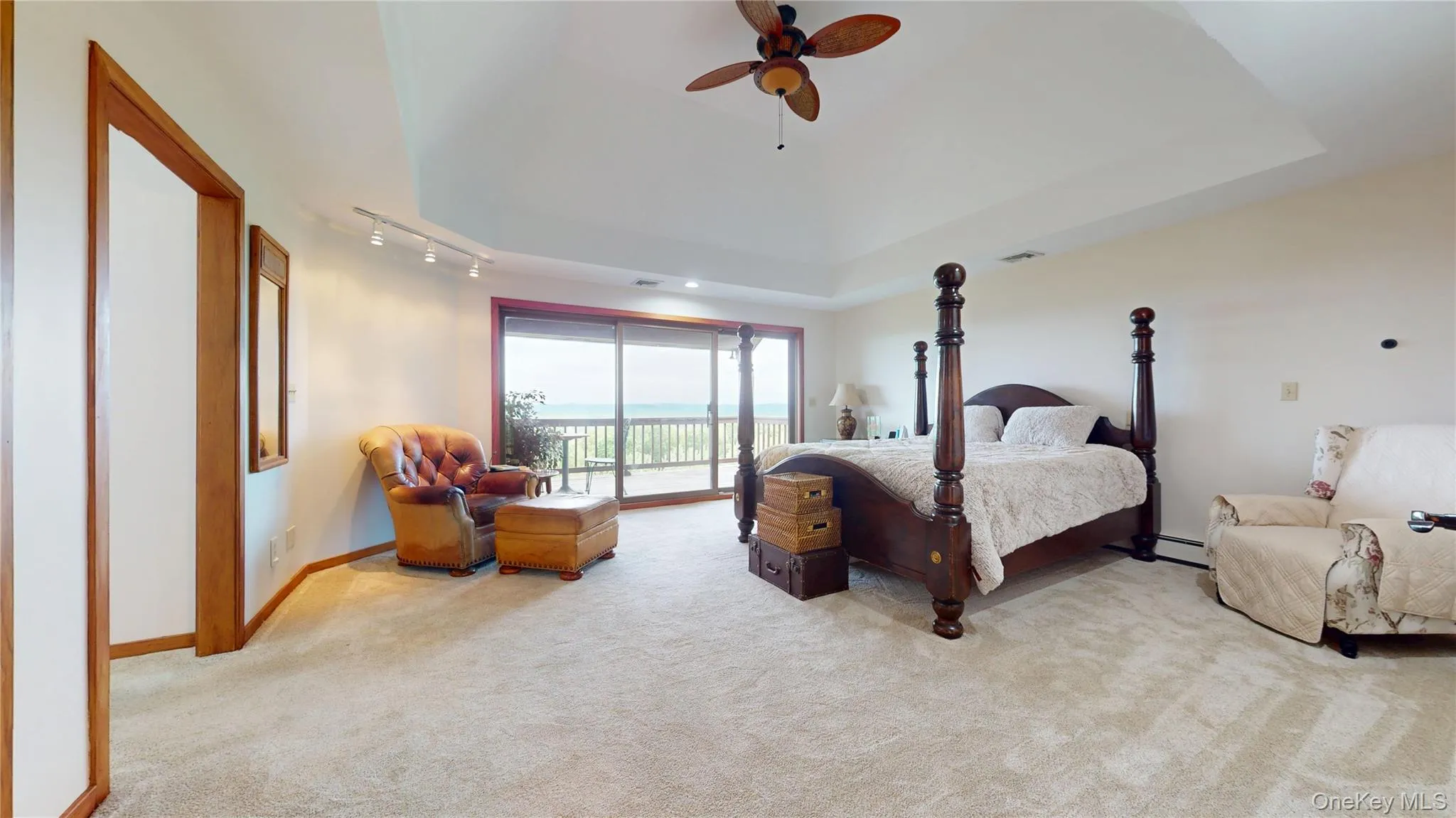 Carpeted room with a tray ceiling and a ceiling fan Carpeted room with a tray ceiling and a ceiling fan