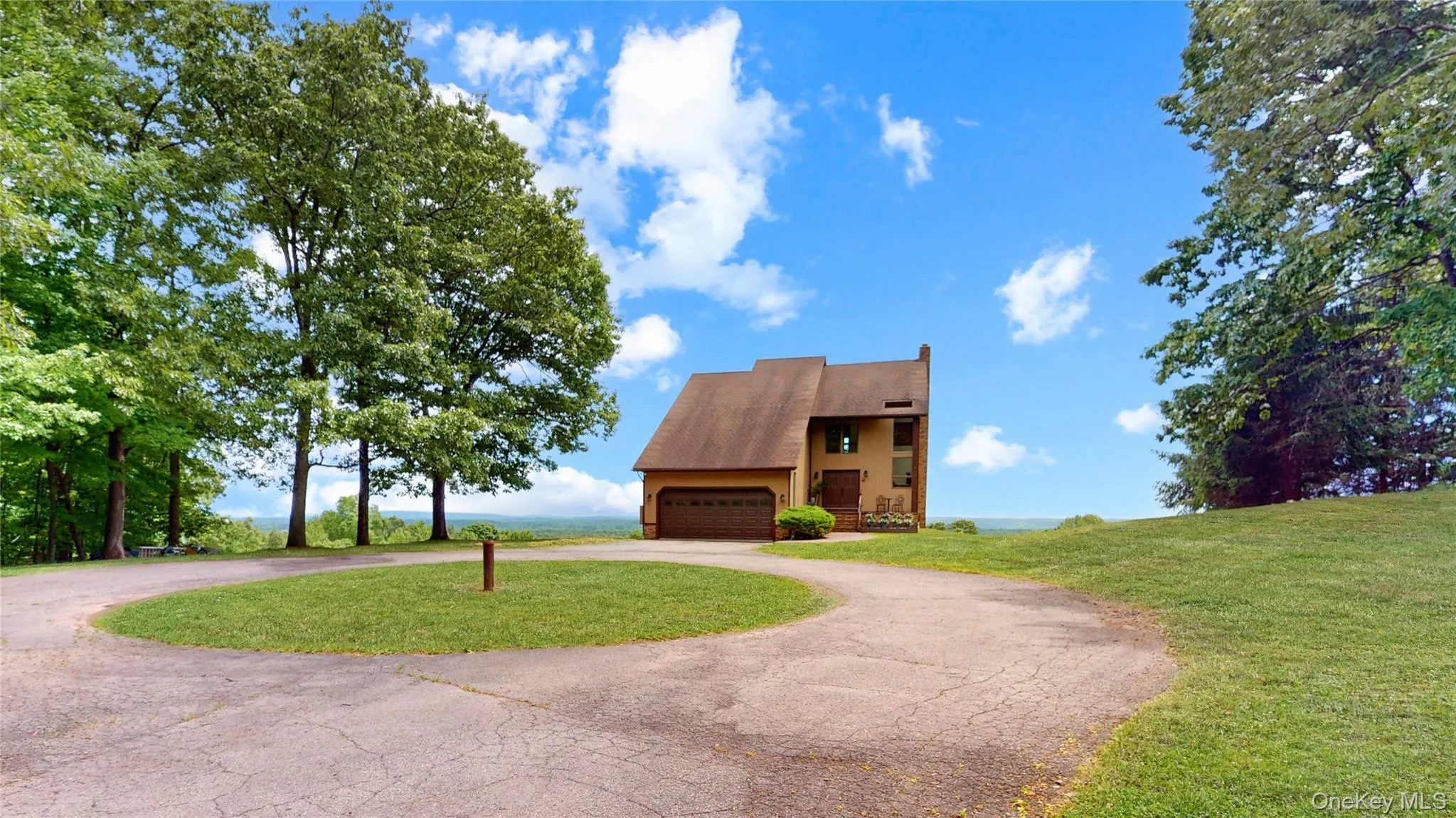 Split-level residence featuring a two-car garage and a paved circular driveway Split-level residence featuring a two-car garage and a paved circular driveway
