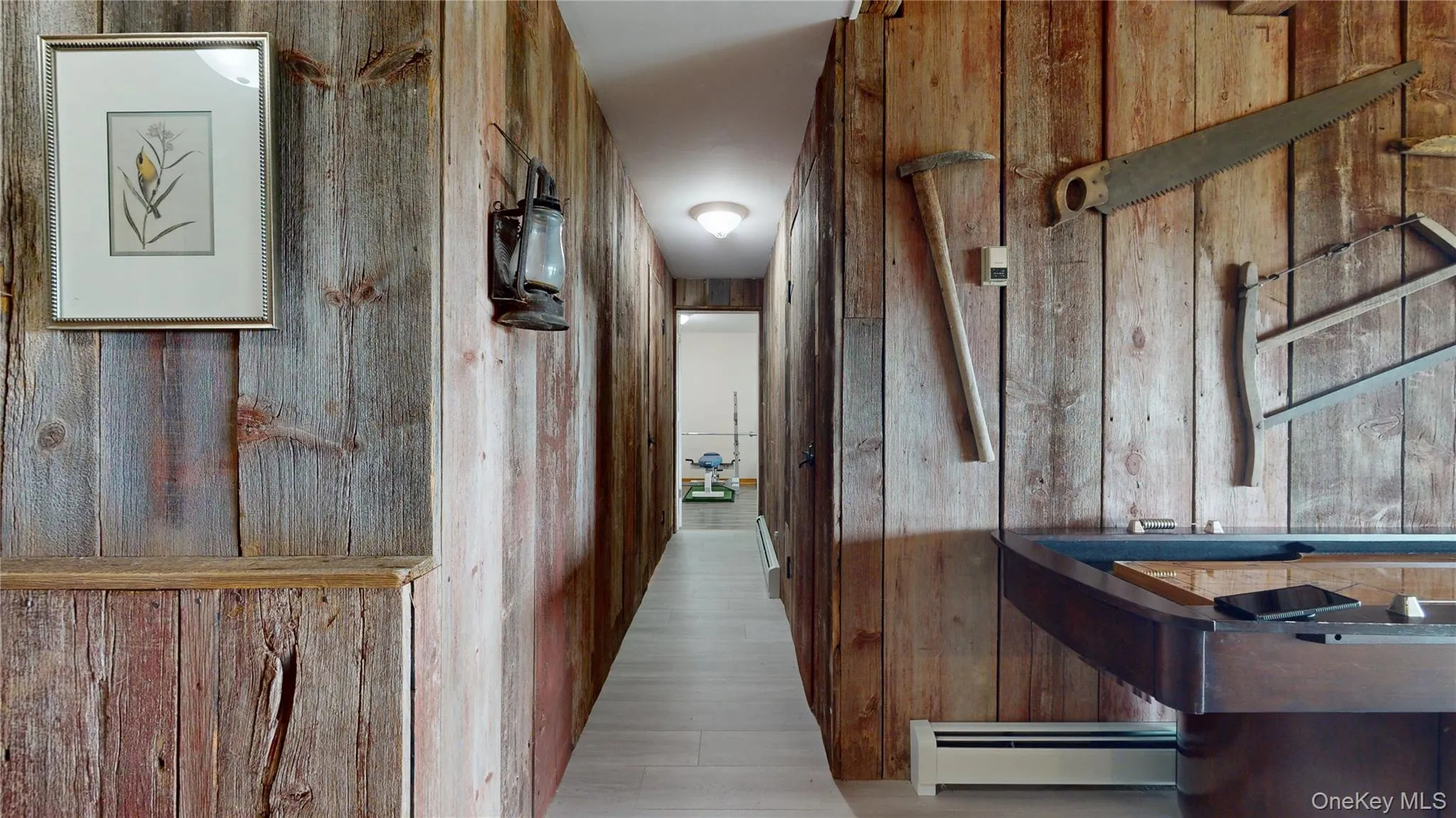 Hallway featuring wood-finish wall paneling, light wood-finish flooring, and recessed ceiling lighting Hallway featuring wood-finish wall paneling, light wood-finish flooring, and recessed ceiling lighting