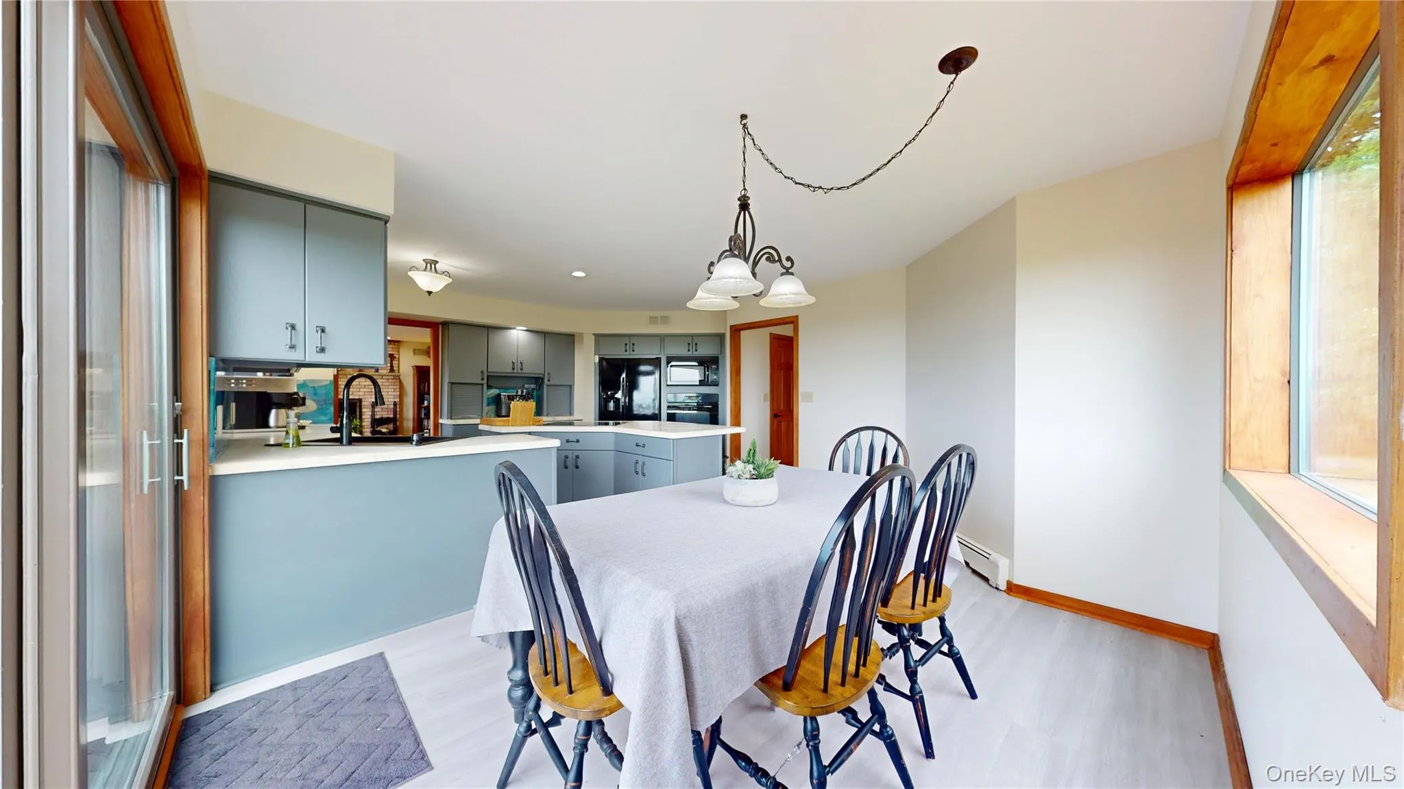 Dining area featuring a contemporary chandelier and wood-finish flooring Dining area featuring a contemporary chandelier and wood-finish flooring