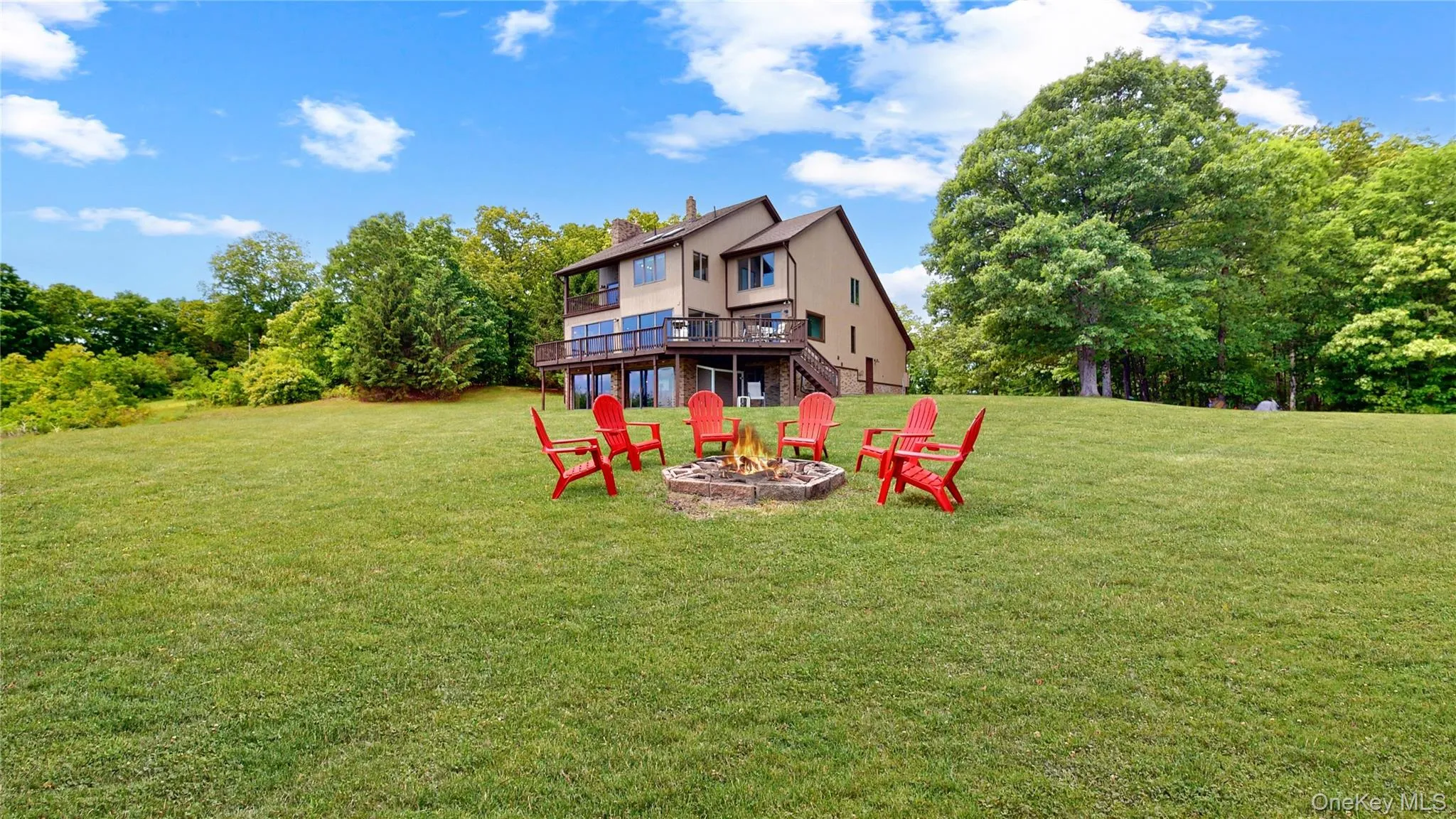 Expansive green lawn with a stone fire pit Expansive green lawn with a stone fire pit