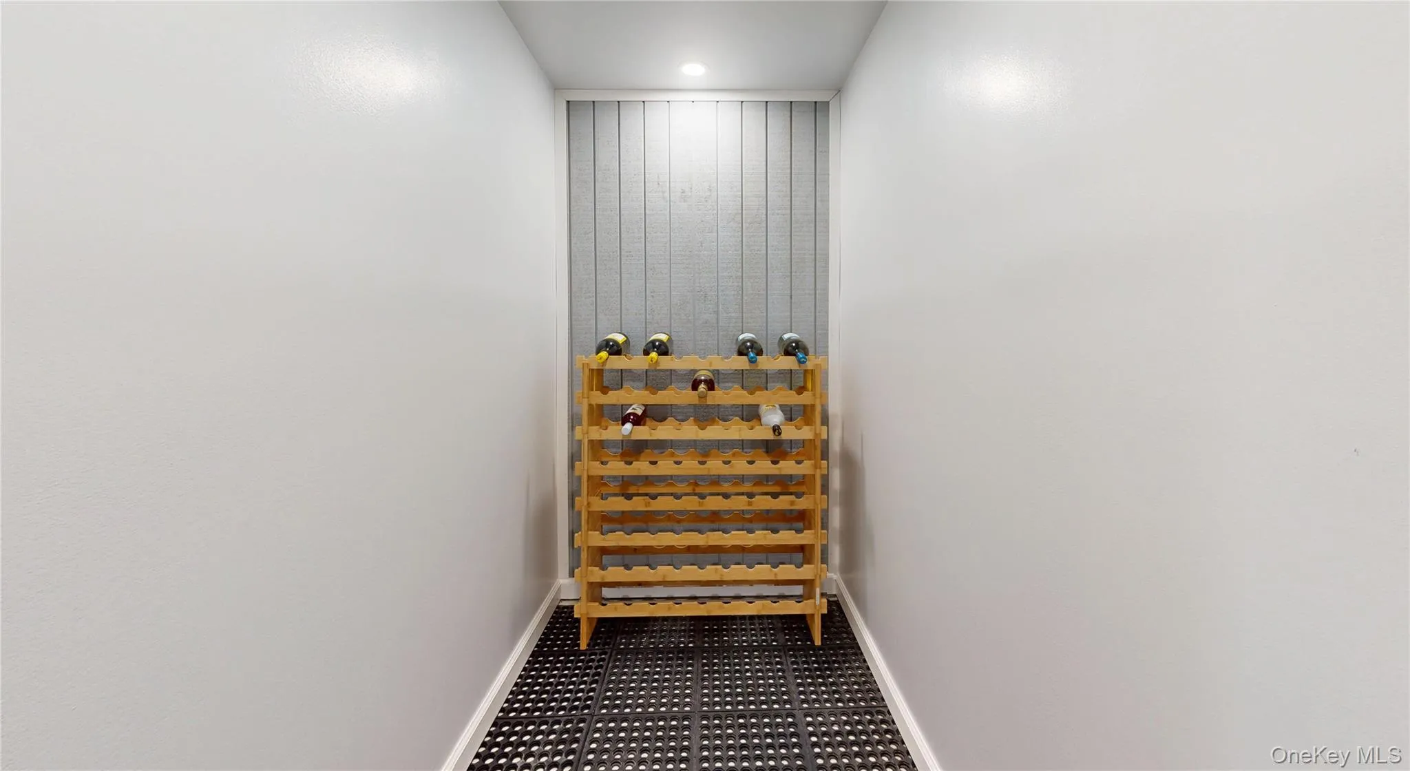 Dedicated storage area featuring a textured accent wall, recessed lighting, and black and white floor tiling Dedicated storage area featuring a textured accent wall, recessed lighting, and black and white floor tiling