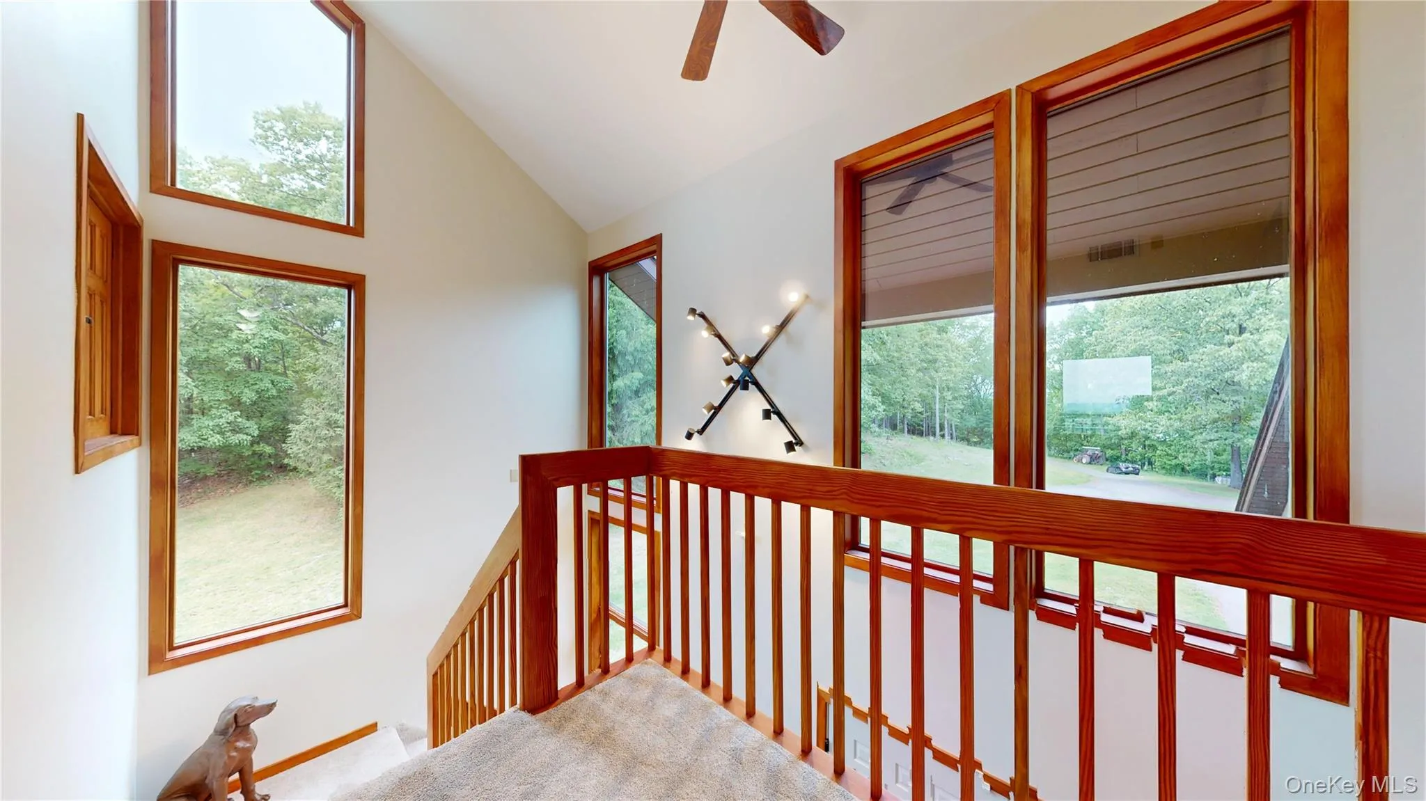 Vaulted ceiling stairway with natural wood window frames and matching wood railings Vaulted ceiling stairway with natural wood window frames and matching wood railings