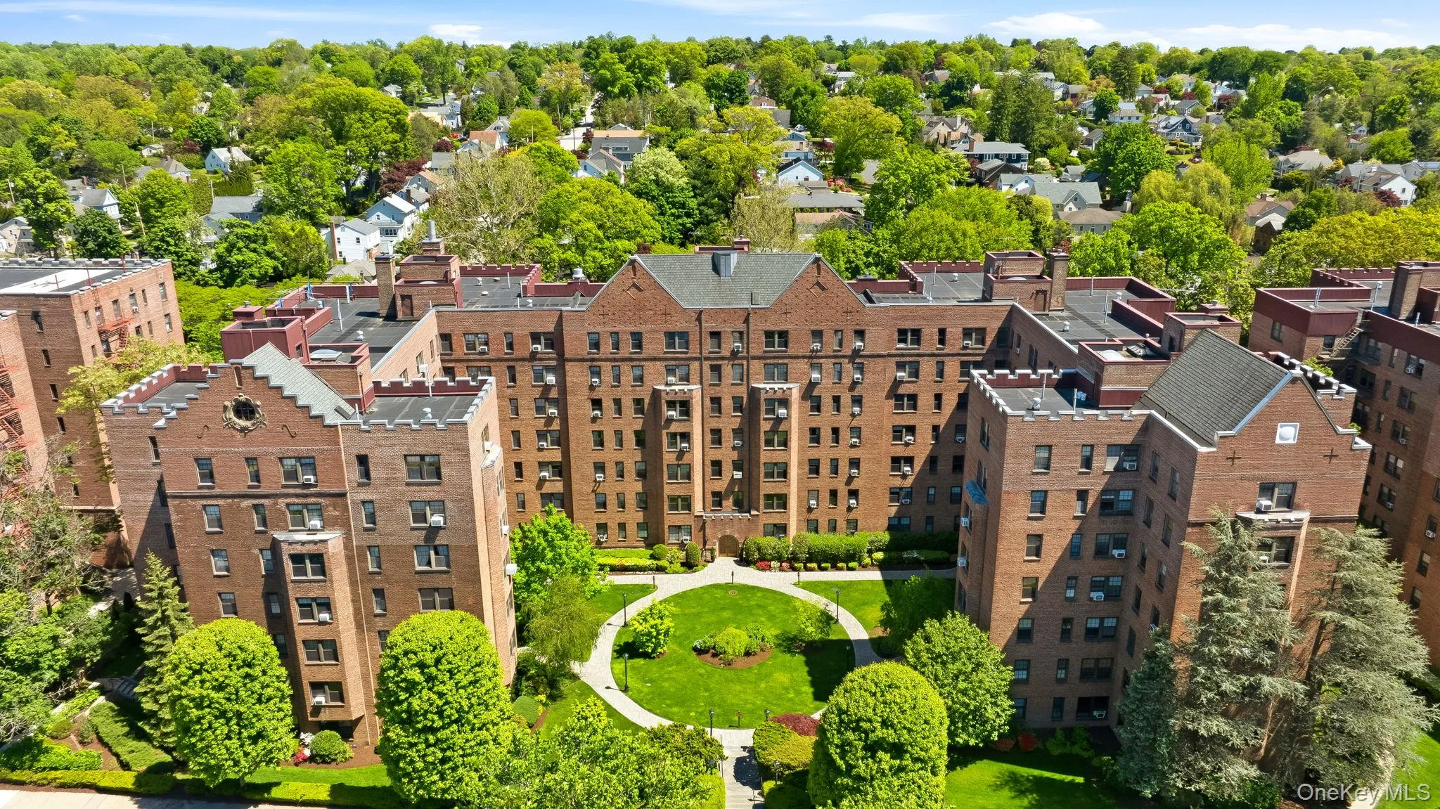 Aerial view showcasing the beautifully maintained grounds and courtyard layout of the building. Aerial view showcasing the beautifully maintained grounds and courtyard layout of the building.