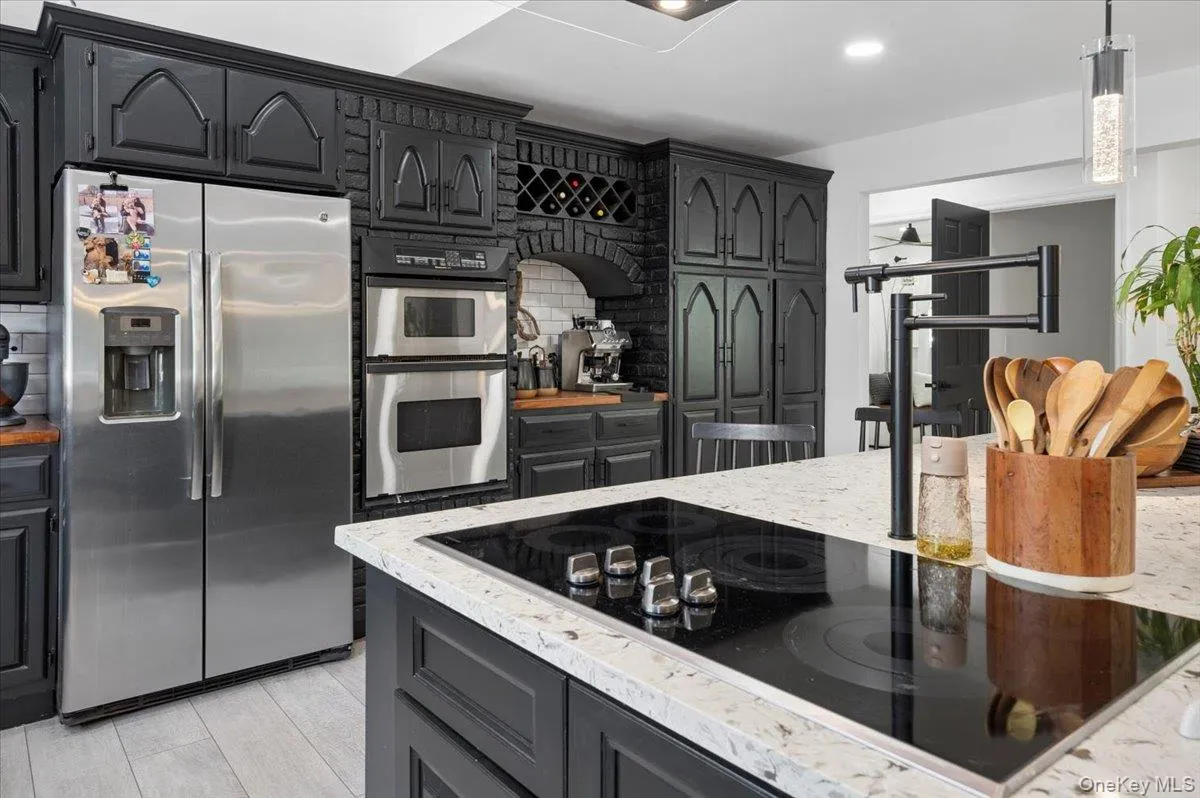 Showstopper Kitchen: A masterclass in design featuring sleek black cabinetry, warm butcher-block perimeters, and a massive waterfall quartz island with ample seating. Showstopper Kitchen: A masterclass in design featuring sleek black cabinetry, warm butcher-block perimeters, and a massive waterfall quartz island with ample seating.