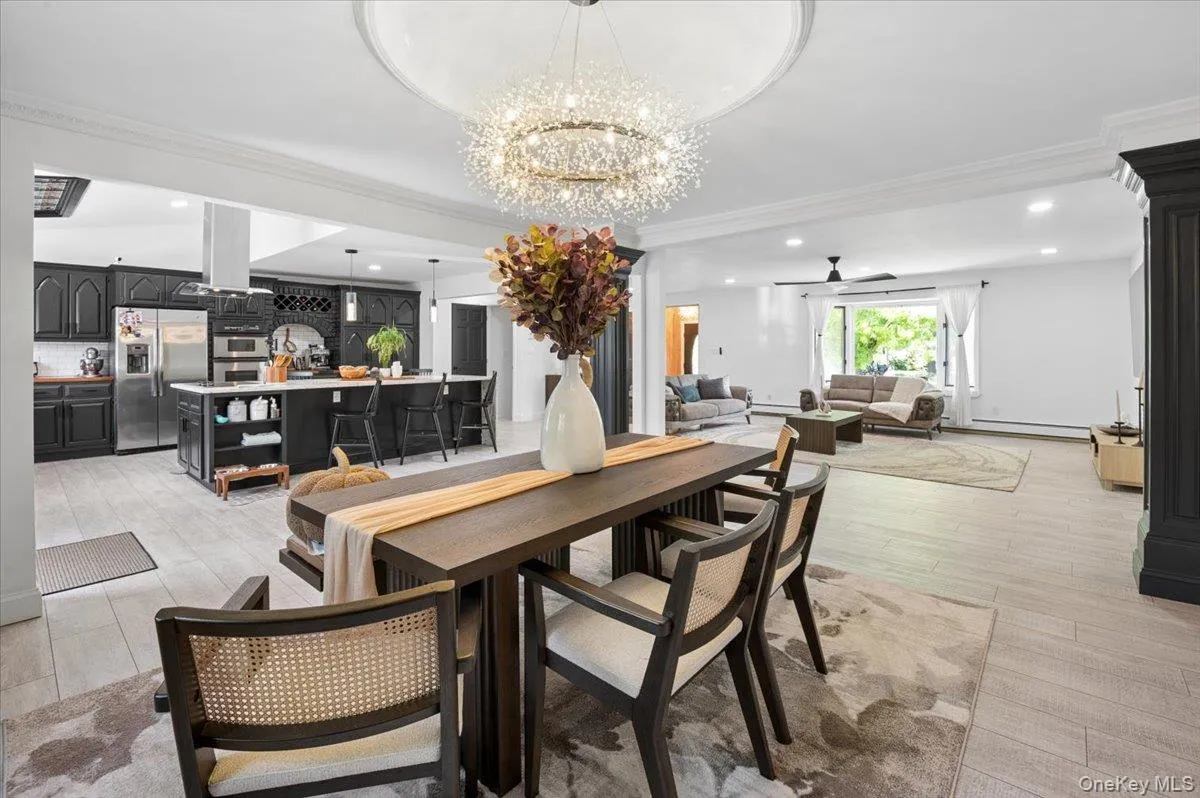 Open-concept interior featuring light-tone flooring, a sparkling chandelier, and recessed lighting. Open-concept interior featuring light-tone flooring, a sparkling chandelier, and recessed lighting.