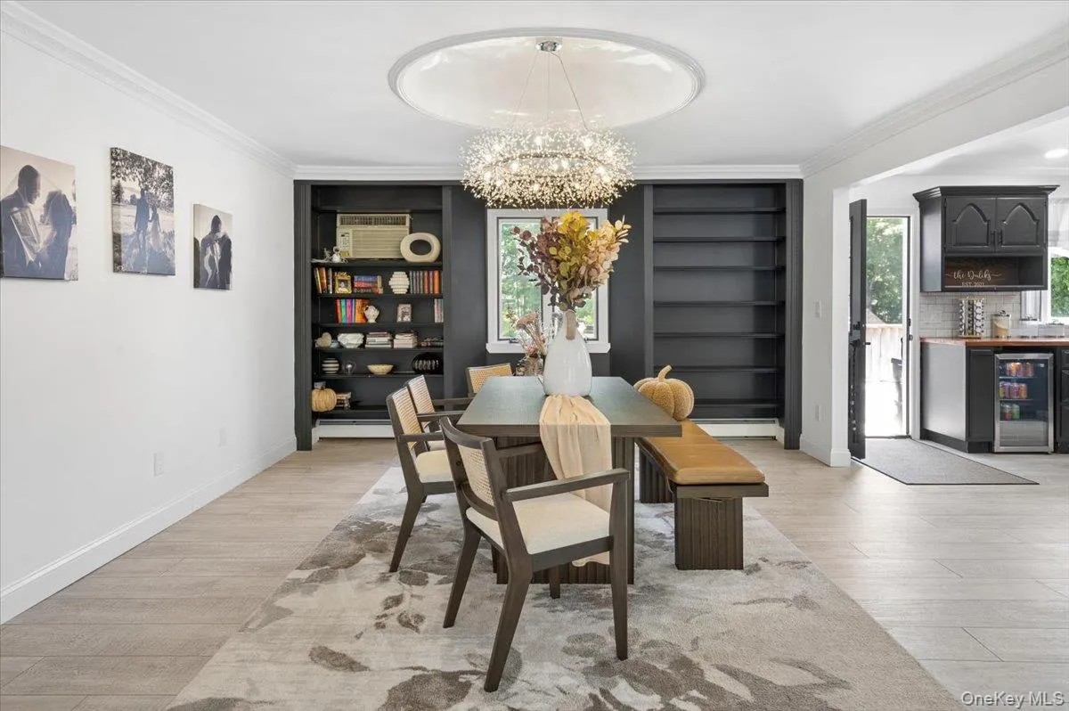 Elegant Dining: The adjacent dining area boasts a striking modern chandelier and custom built-in shelving—perfect for intimate dinners or grand celebrations. Elegant Dining: The adjacent dining area boasts a striking modern chandelier and custom built-in shelving—perfect for intimate dinners or grand celebrations.