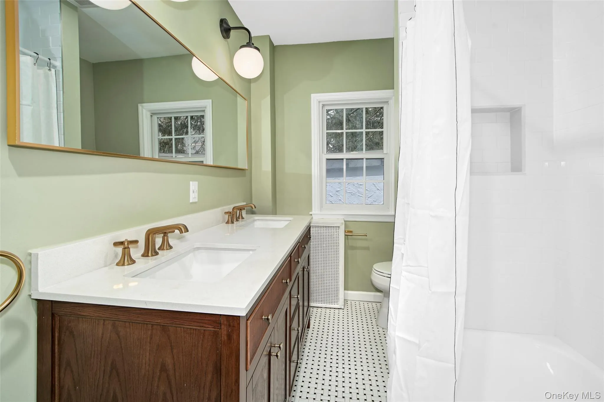 Dual vanity with integrated sinks, white countertop, and brass-finish hardware bonus laundry in the closet off the kitchen Dual vanity with integrated sinks, white countertop, and brass-finish hardware bonus laundry in the closet off the kitchen