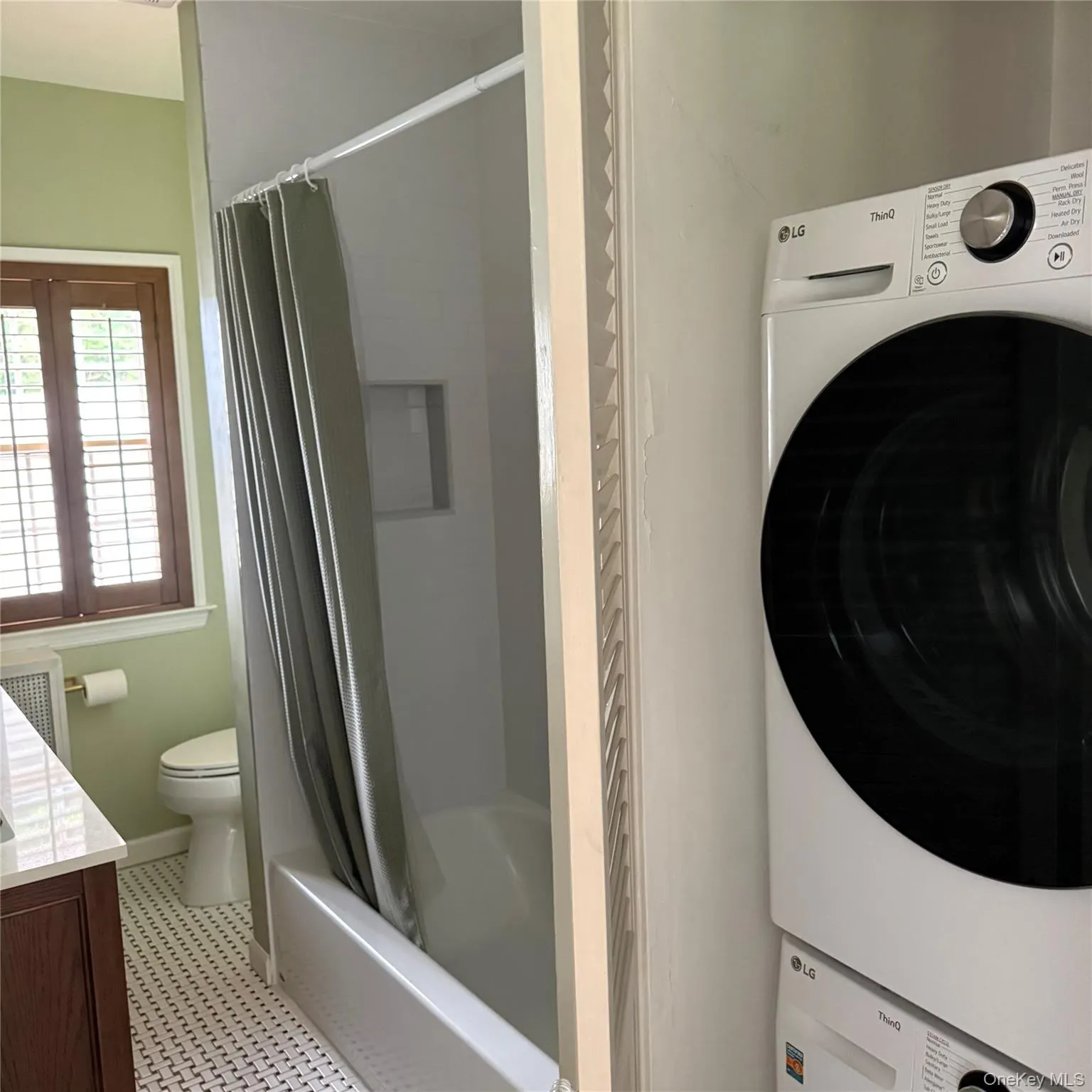 Bathroom with a white tiled floor, dark wood vanity with a light-colored countertop, and a white bathtub Bathroom with a white tiled floor, dark wood vanity with a light-colored countertop, and a white bathtub