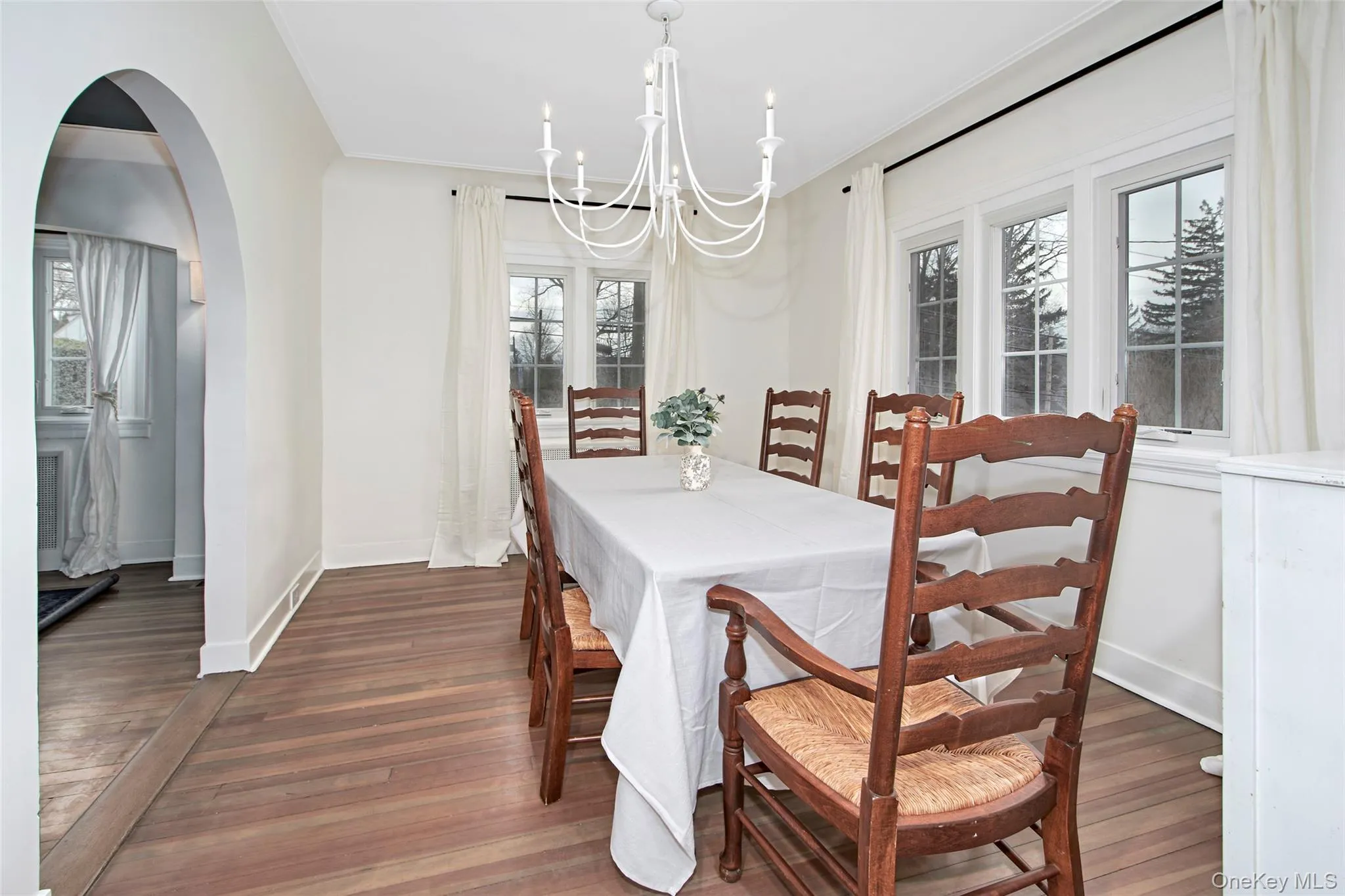Dining area with dark hardwood / wood-style flooring, ornamental molding, and a chandelier Dining area with dark hardwood / wood-style flooring, ornamental molding, and a chandelier
