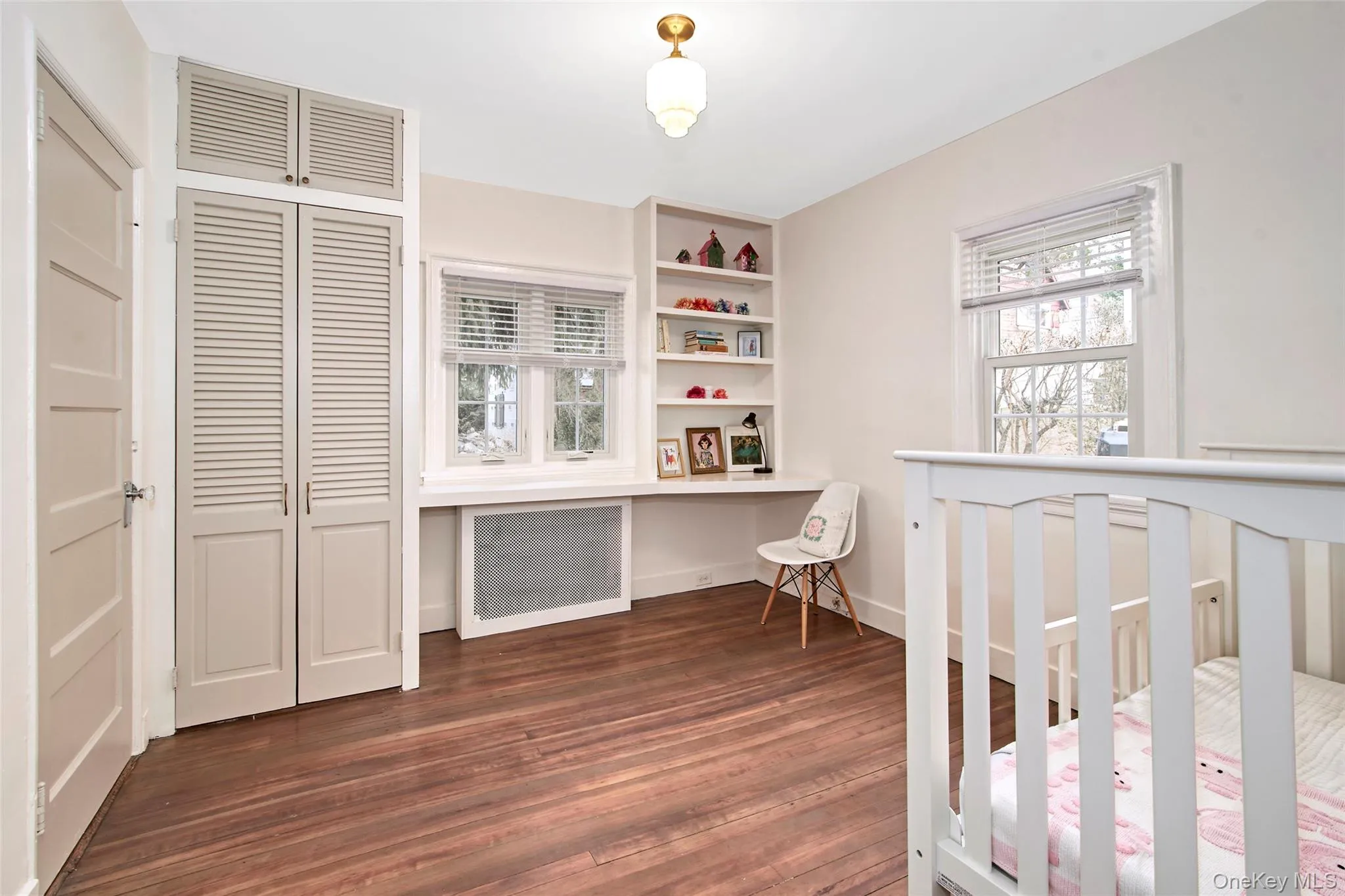 Hardwood flooring, louvered bi-fold closet doors, built-in shelving, built-in desk, and double windows Hardwood flooring, louvered bi-fold closet doors, built-in shelving, built-in desk, and double windows