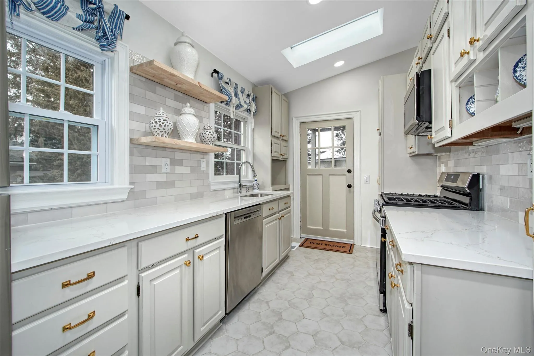 New Kitchen with lofted ceiling with skylight, sink, tasteful backsplash, appliances with stainless steel finishes, and light stone countertops New Kitchen with lofted ceiling with skylight, sink, tasteful backsplash, appliances with stainless steel finishes, and light stone countertops