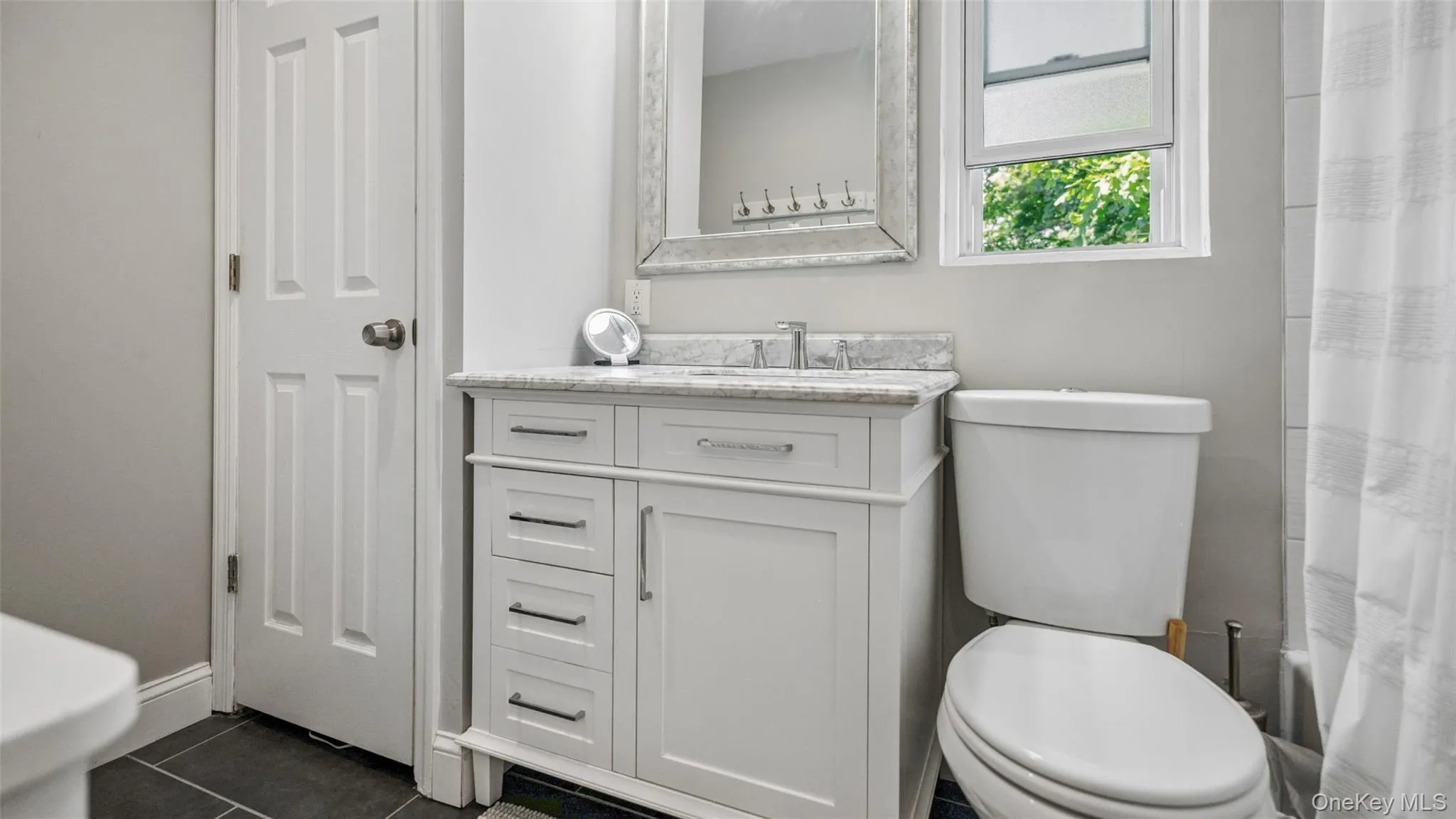 White vanity with a light-toned countertop and an integrated sink White vanity with a light-toned countertop and an integrated sink