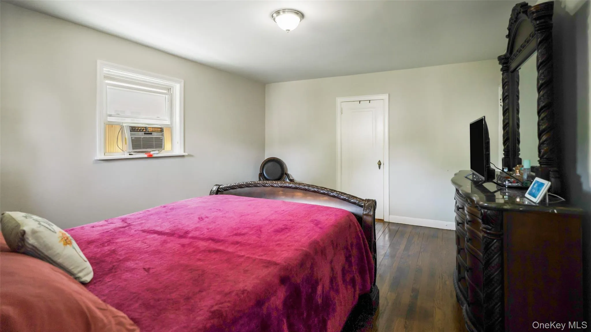 Light-toned wall paint and dark wood-finish flooring characterize this room Light-toned wall paint and dark wood-finish flooring characterize this room