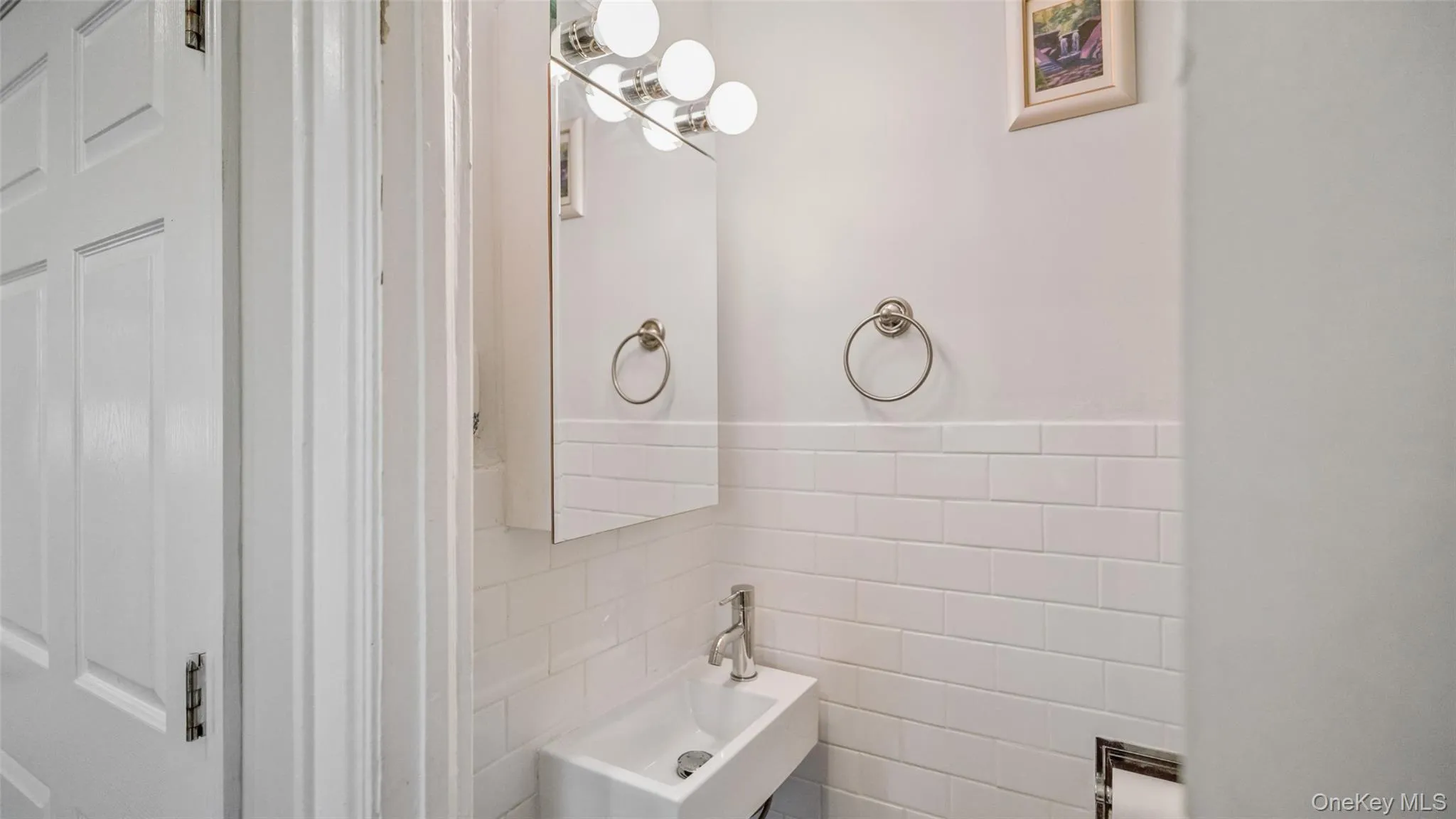 Compact white vanity with an integrated sink and chrome faucet Compact white vanity with an integrated sink and chrome faucet