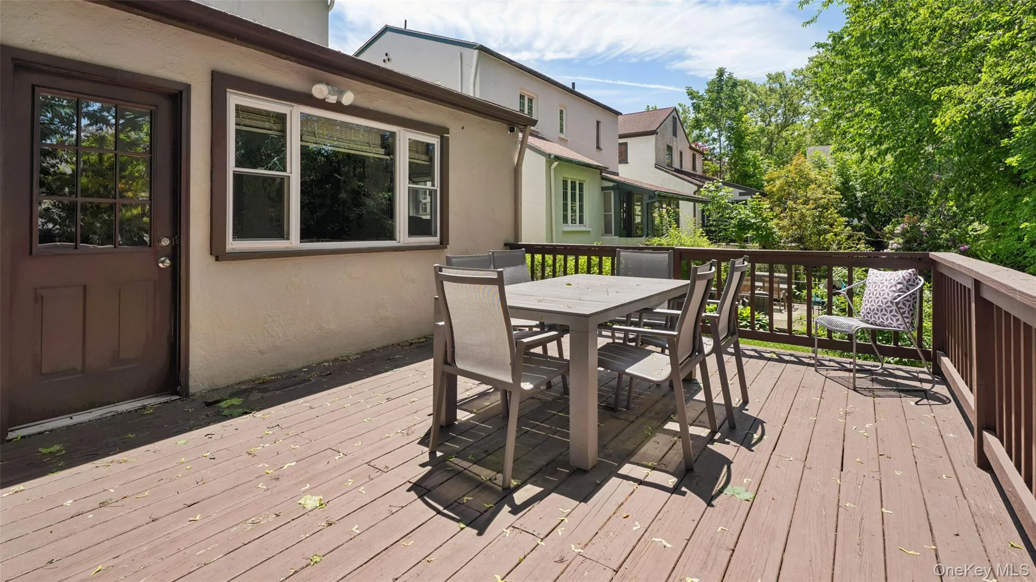 Spacious outdoor deck featuring brown-stained wood planking and coordinating railings Spacious outdoor deck featuring brown-stained wood planking and coordinating railings