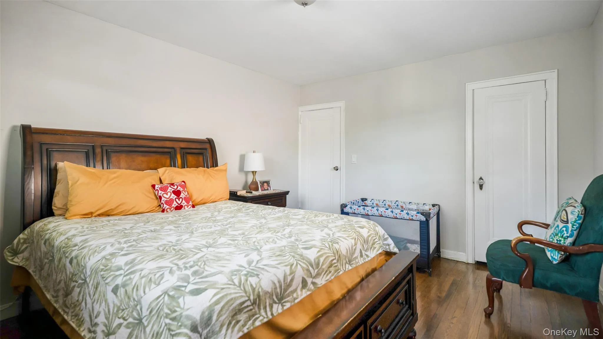 Bedroom featuring wood-finish flooring, light-toned walls, and white panel doors Bedroom featuring wood-finish flooring, light-toned walls, and white panel doors