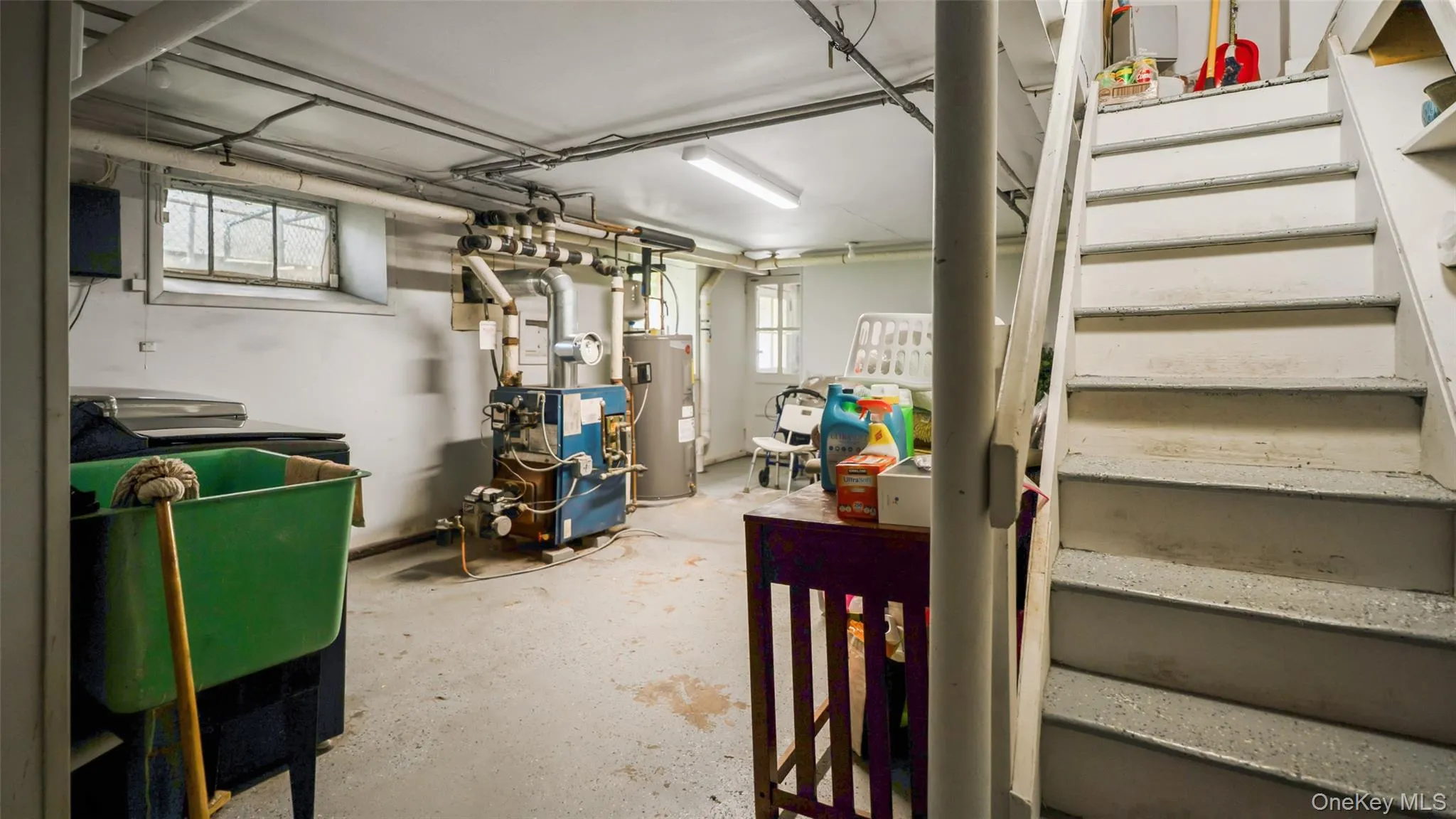 Utility space featuring a water heater, boiler system, and laundry sink Utility space featuring a water heater, boiler system, and laundry sink
