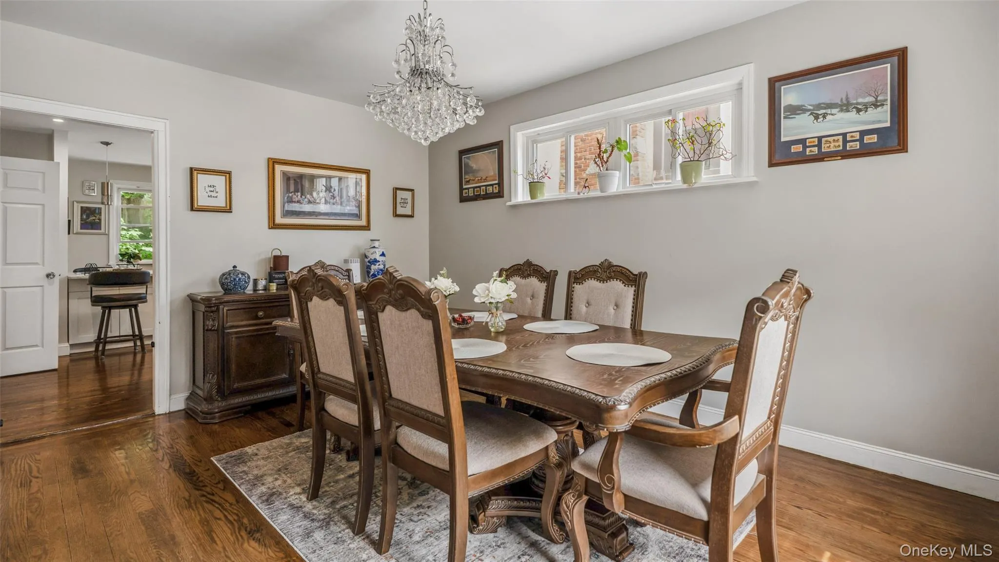 Dining area featuring wood-finish flooring, a crystal chandelier, and a built-in window shelf Dining area featuring wood-finish flooring, a crystal chandelier, and a built-in window shelf
