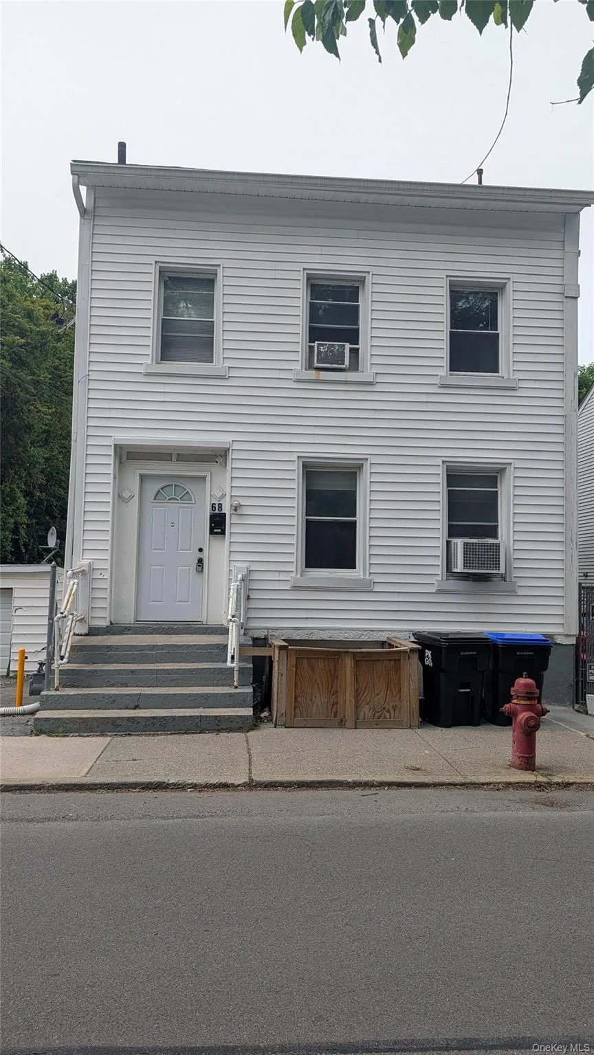Three-story property featuring white horizontal siding and a white entry door Three-story property featuring white horizontal siding and a white entry door