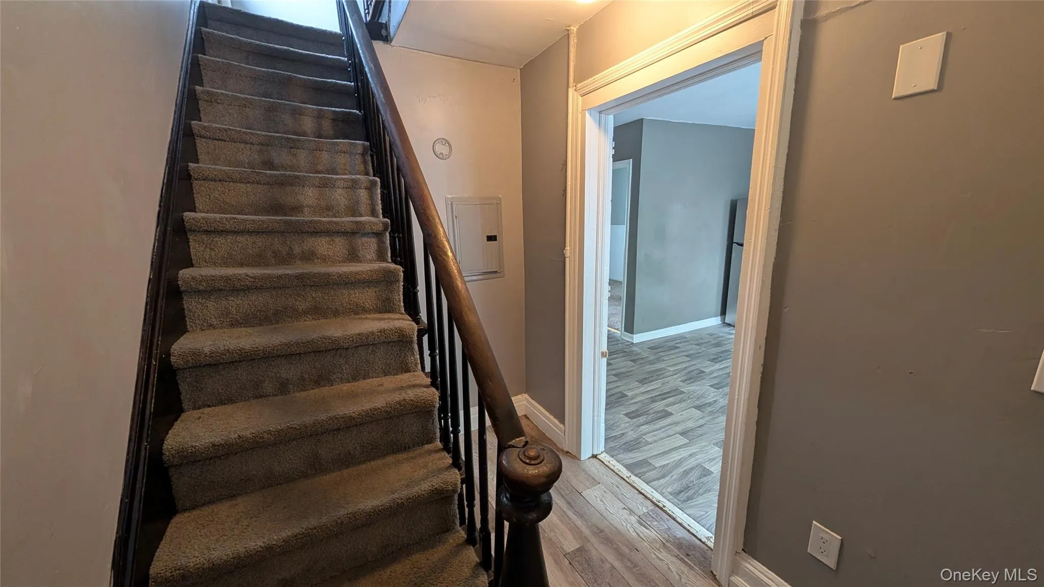 Carpeted staircase with dark wood-finish handrail and balusters Carpeted staircase with dark wood-finish handrail and balusters
