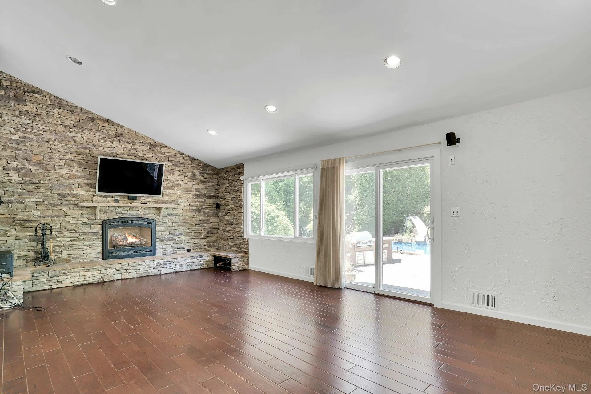 Decorative stone wall with fireplace and sliders out to the yard. Decorative stone wall with fireplace and sliders out to the yard.