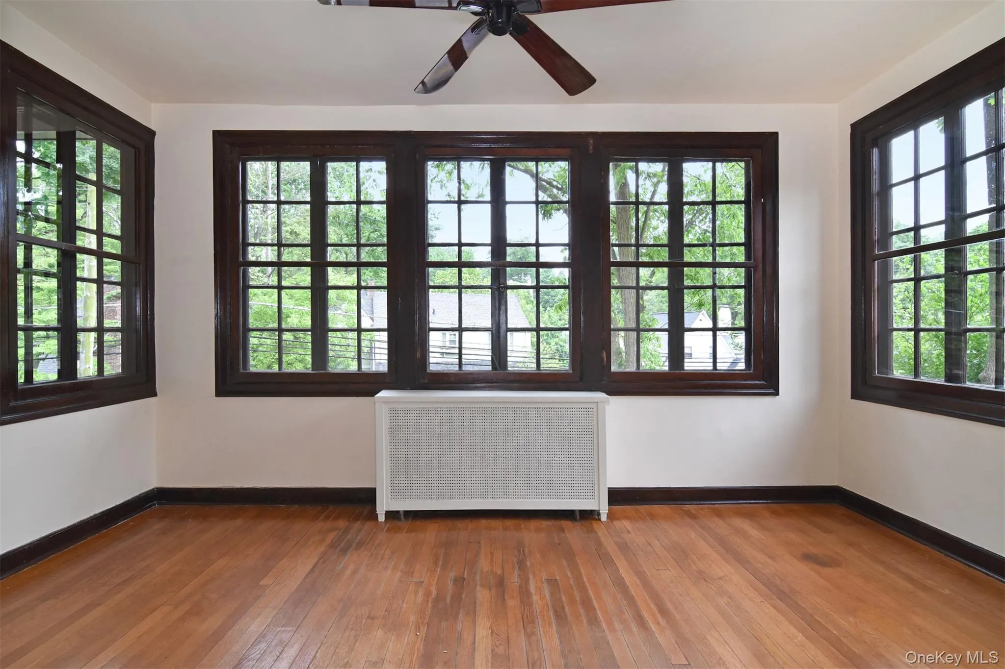 Inviting sun room with hardwood floors and large windows Inviting sun room with hardwood floors and large windows