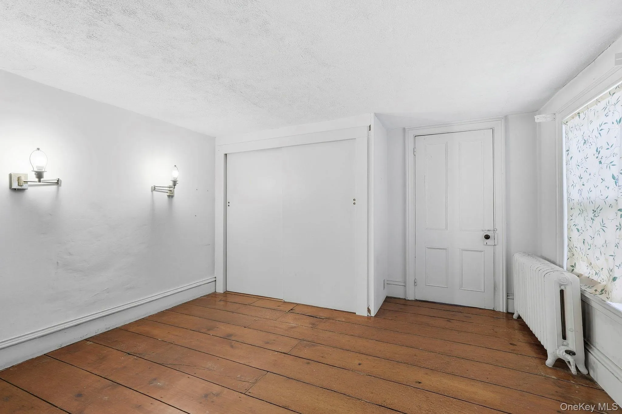 Hardwood plank flooring complements white walls Hardwood plank flooring complements white walls