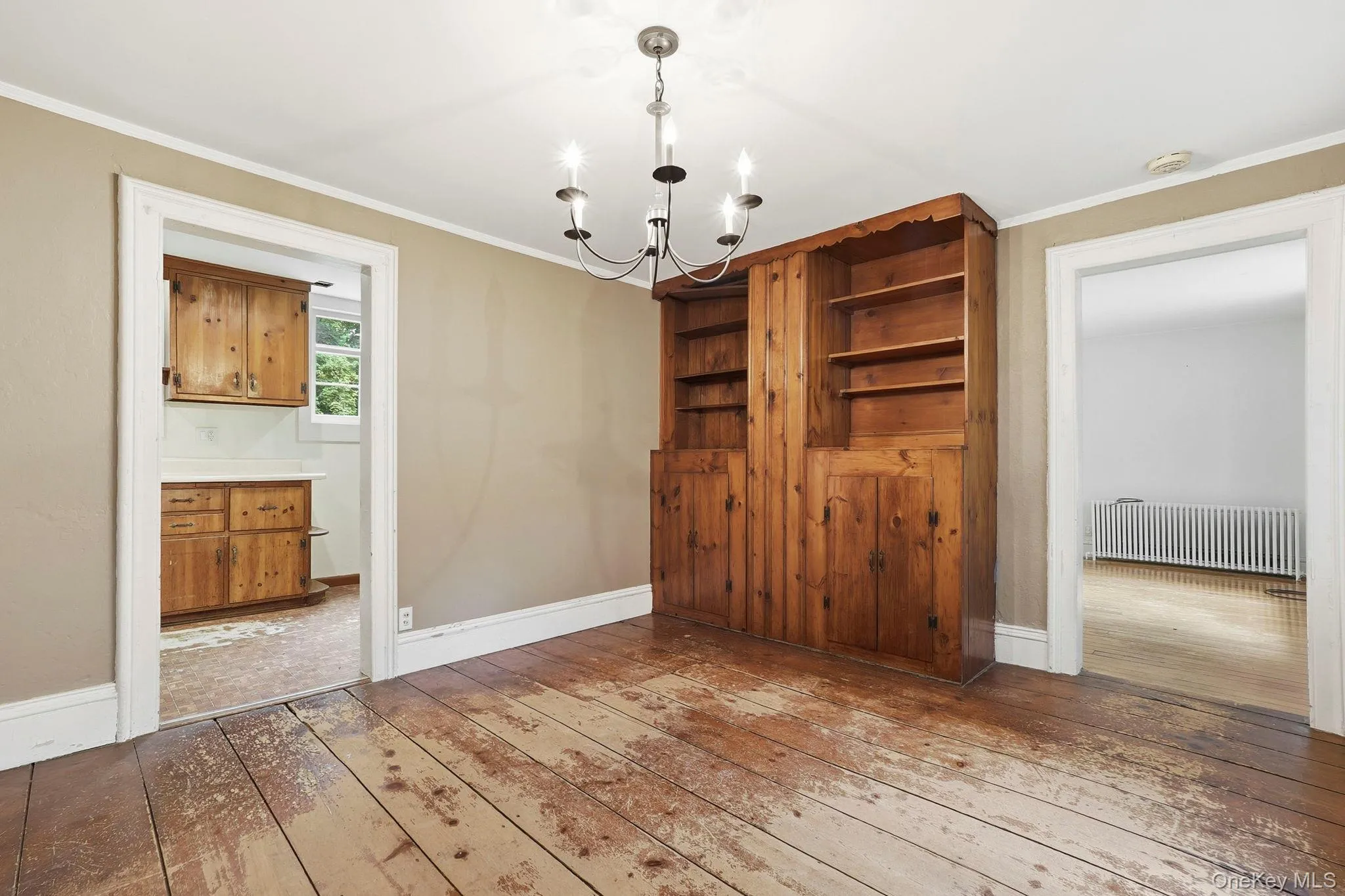 Room featuring a built-in wood-finish cabinet with open shelving and lower storage Room featuring a built-in wood-finish cabinet with open shelving and lower storage