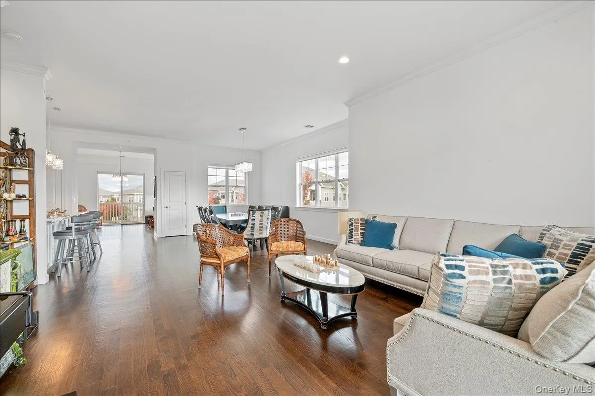 Living area with crown molding, dark wood-style floors, healthy amount ofnatural light, and recessed lighting Living area with crown molding, dark wood-style floors, healthy amount ofnatural light, and recessed lighting
