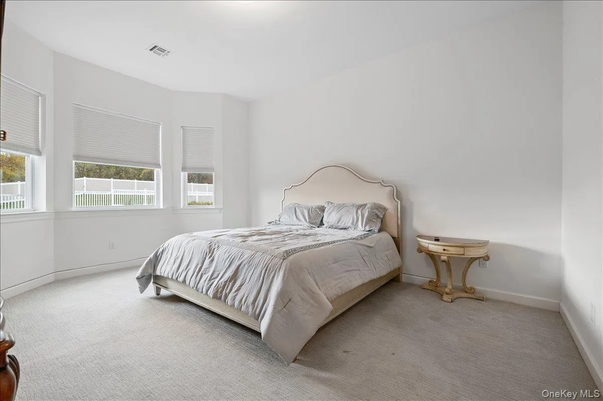 Bedroom with carpet flooringand baseboards Bedroom with carpet flooringand baseboards