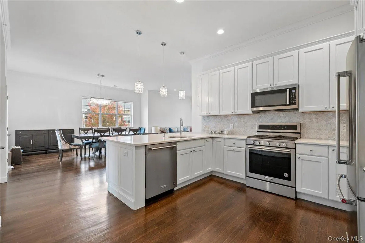 Kitchen with stainless steelappliances, white cabinets, apeninsula, ornamentalmolding, and recessed lighting Kitchen with stainless steelappliances, white cabinets, apeninsula, ornamentalmolding, and recessed lighting