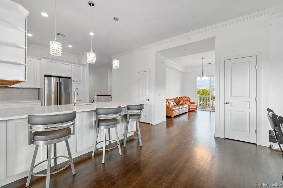 Kitchen with open shelves,white cabinets, crown molding,a breakfast bar, and decorativebacksplash Kitchen with open shelves,white cabinets, crown molding,a breakfast bar, and decorativebacksplash