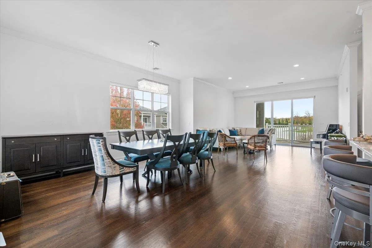 Dining space featuring ornamental molding, plenty ofnatural light, dark wood-styleflooring, and recessed lighting Dining space featuring ornamental molding, plenty ofnatural light, dark wood-styleflooring, and recessed lighting