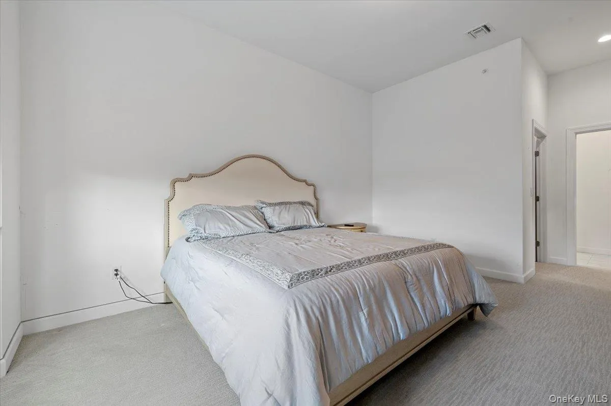 Bedroom featuring light carpet and baseboards Bedroom featuring light carpet and baseboards