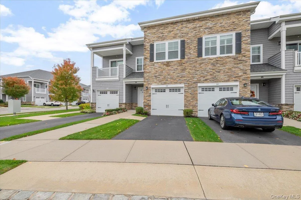 View of front of home withstone siding, driveway, abalcony, a garage, and aresidential view View of front of home withstone siding, driveway, abalcony, a garage, and aresidential view