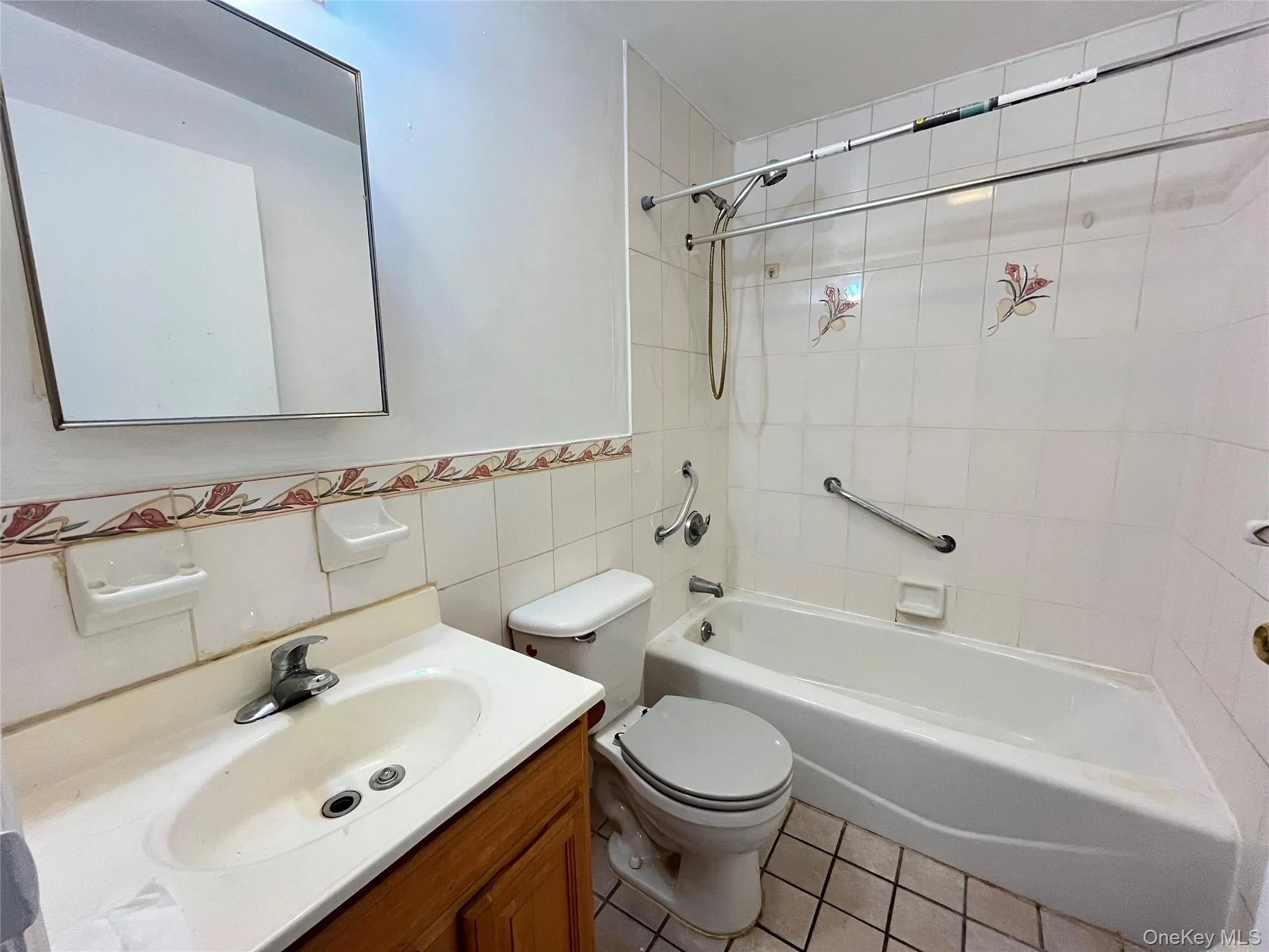 Bathroom featuring a single vanity with wood-finish cabinetry, and a basin sink Bathroom featuring a single vanity with wood-finish cabinetry, and a basin sink