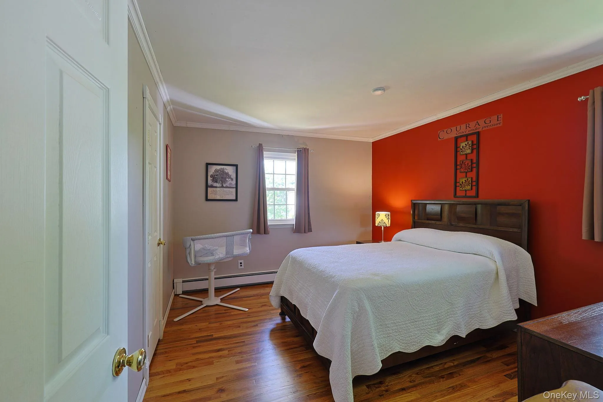 Bedroom featuring hardwood flooring, a double-paned window white crown molding, Bedroom featuring hardwood flooring, a double-paned window white crown molding,