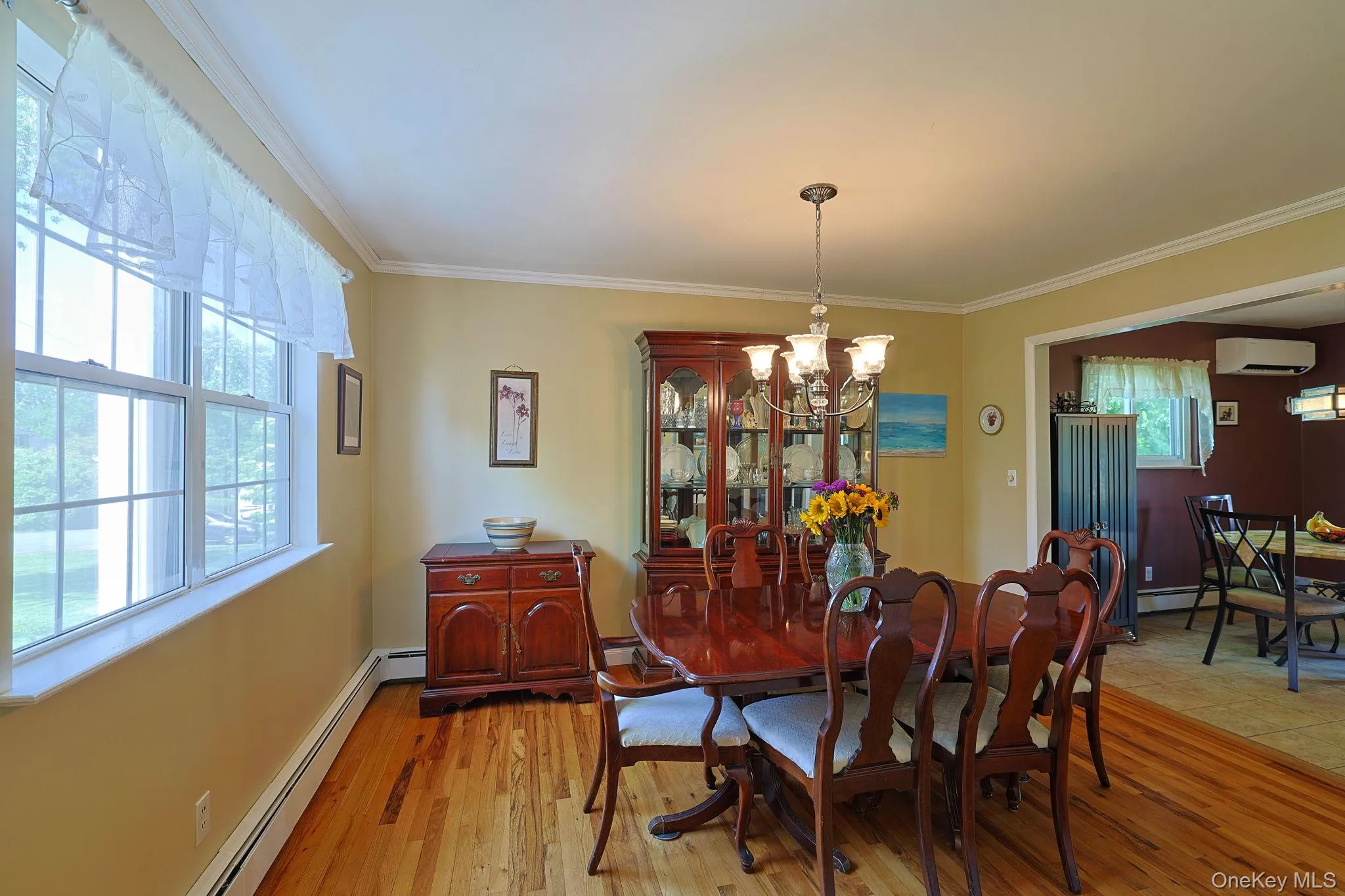 Dining area featuring wood-finish flooring, a multi-light chandelier, and multiple windows Dining area featuring wood-finish flooring, a multi-light chandelier, and multiple windows